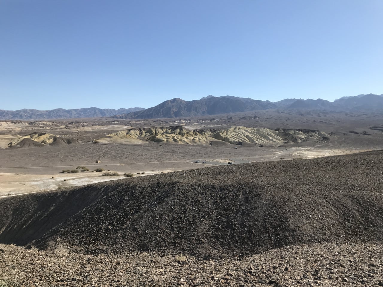 Pouštní údolí Death Valley, barevné hřebeny a silnice pod modrou oblohou