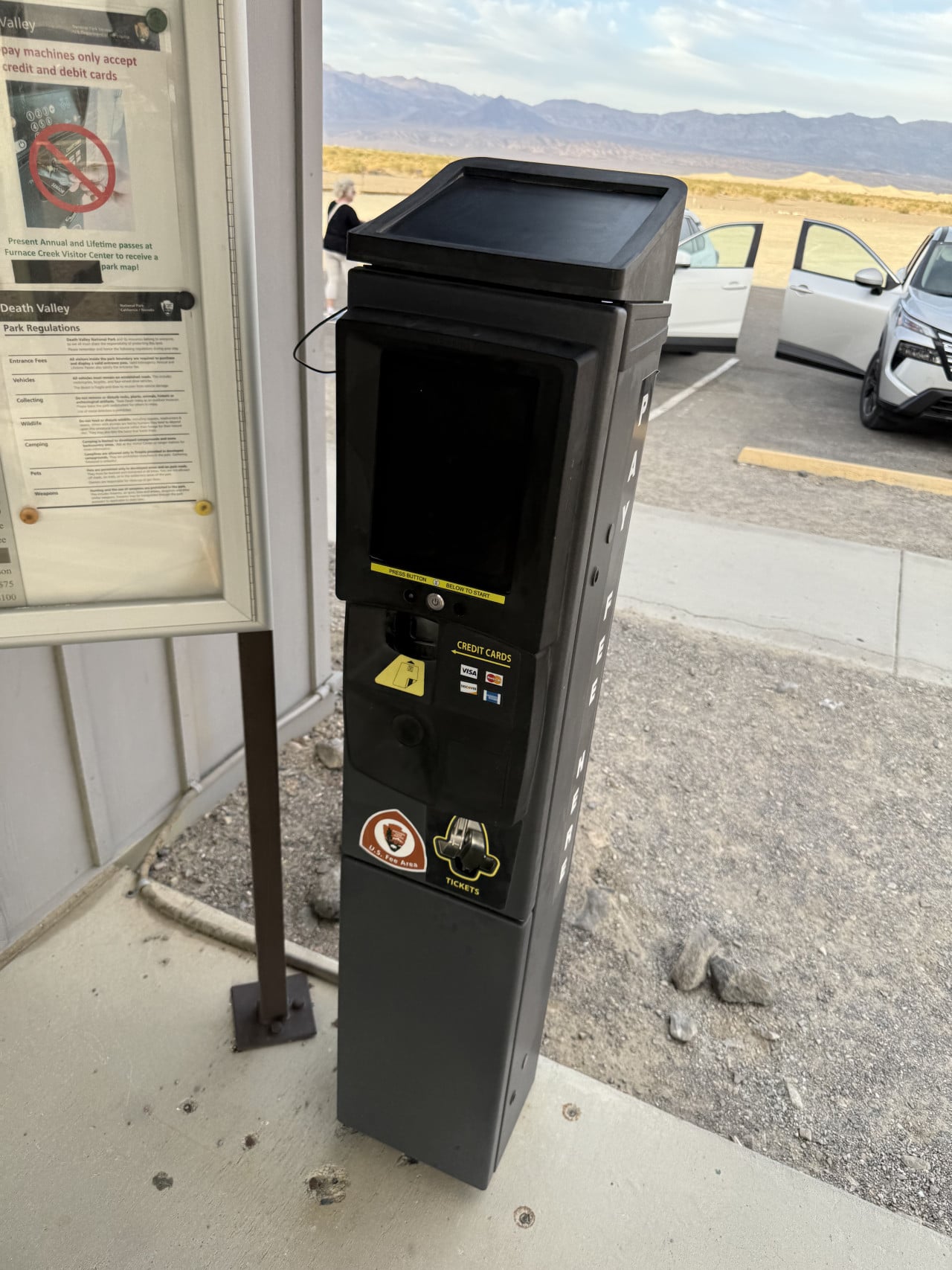 Černý parkovací automat u Death Valley s horami v pozadí