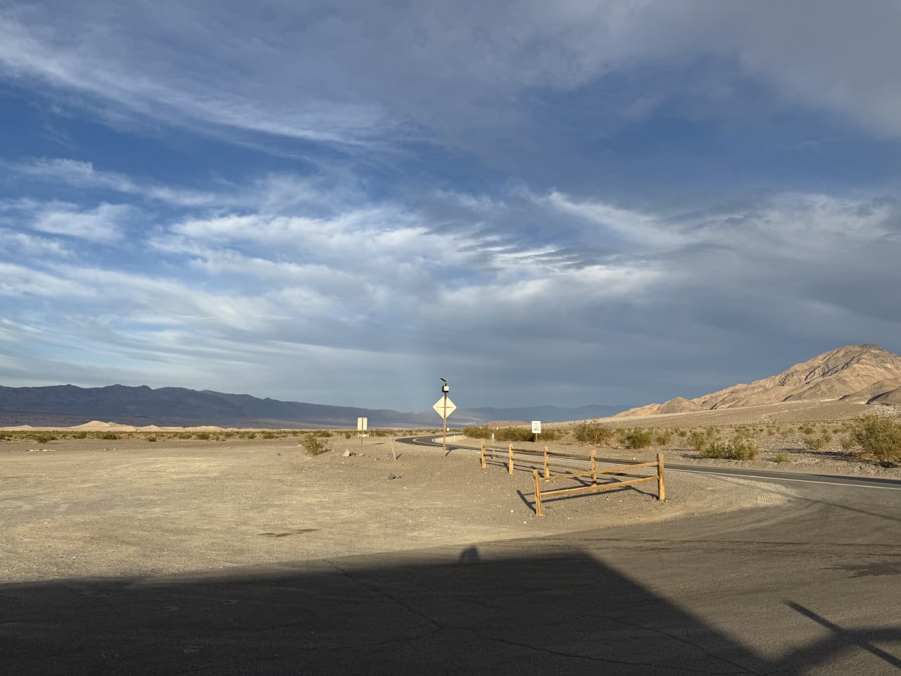 Pouštní silnice v Death Valley, hory a dramatická obloha s mraky