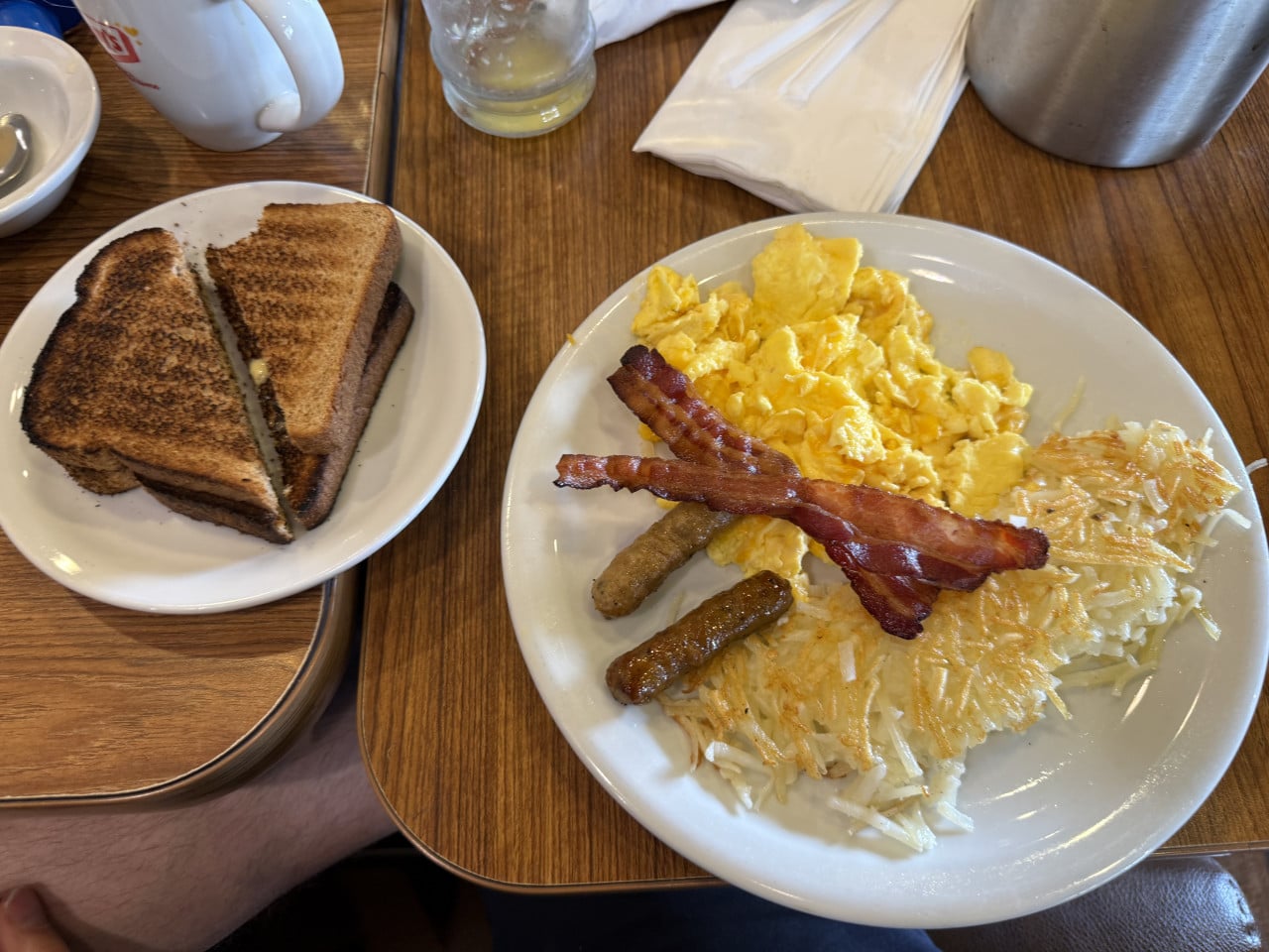 Snídaně v Denny’s: vajíčka, slanina, hash browns a toast na stole