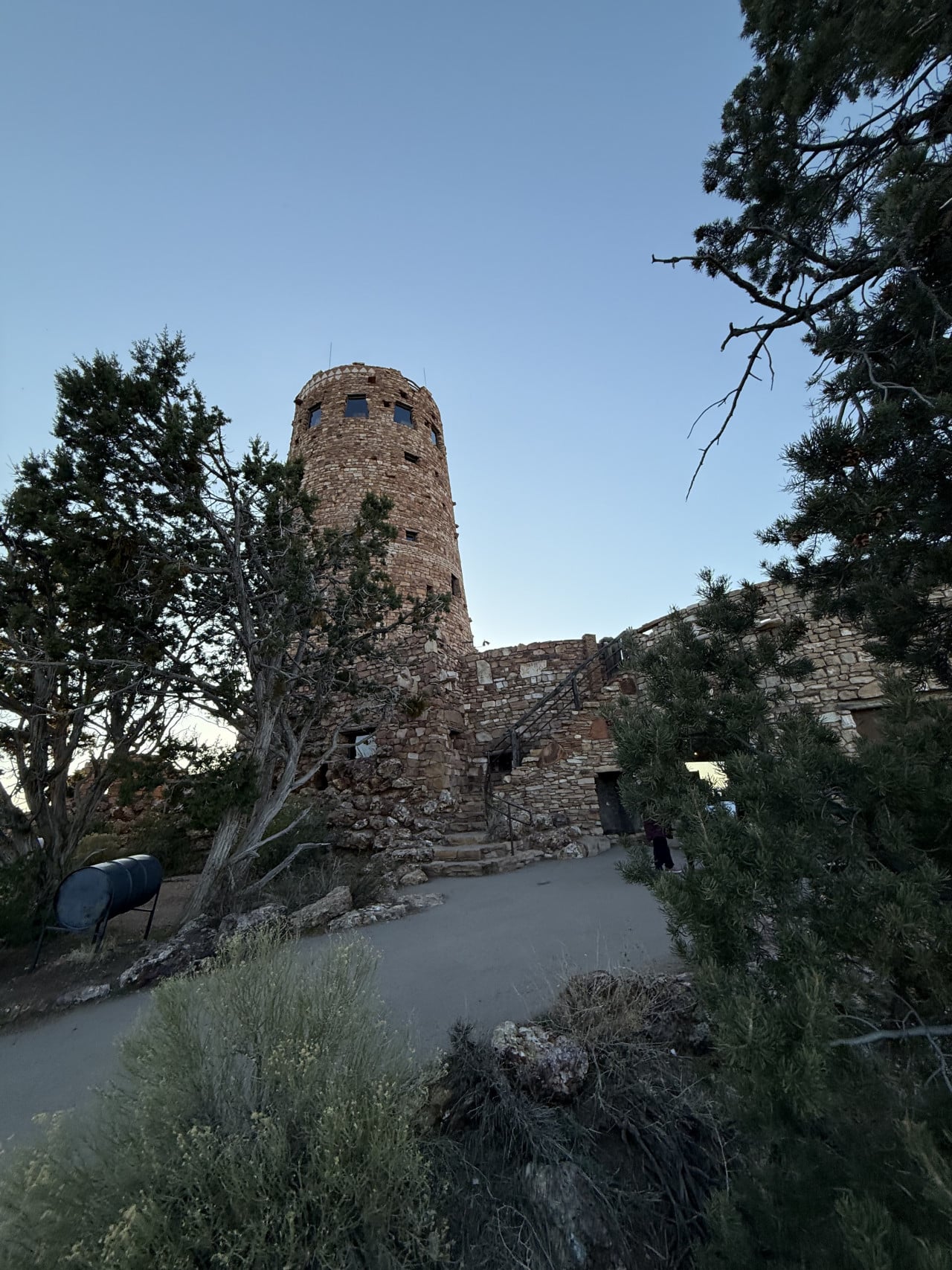 Kamenná věž Desert View Point obklopená stromy při soumraku