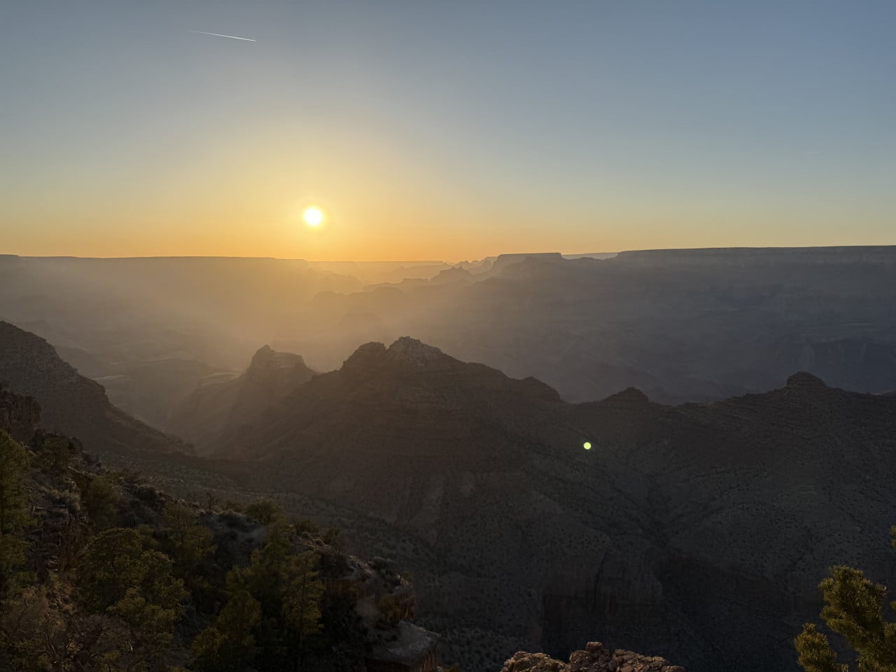 Západ slunce nad Grand Canyonem z vyhlídky Desert View, s mlžným oparům nad kaňonem.
