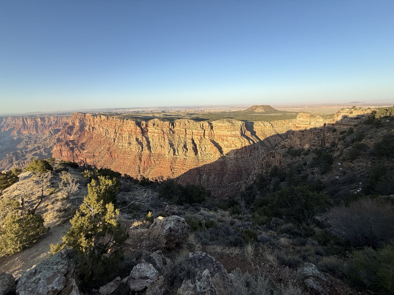 Západ slunce nad Grand Canyonem, osvětlené skalní stěny a kaňon v popředí