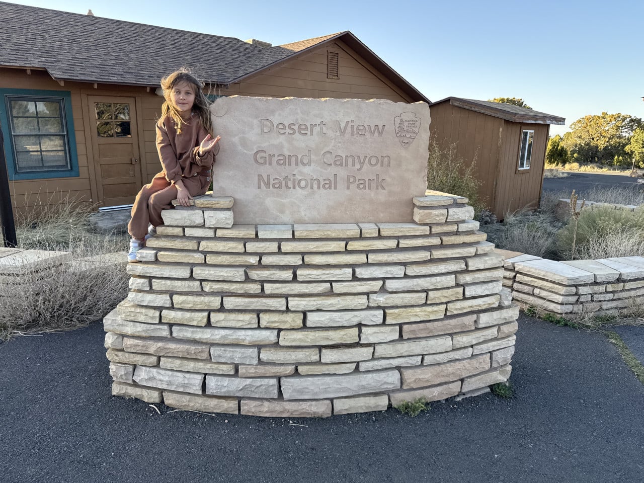 Dívka sedí na kamenném značení Desert View Grand Canyon National Park.