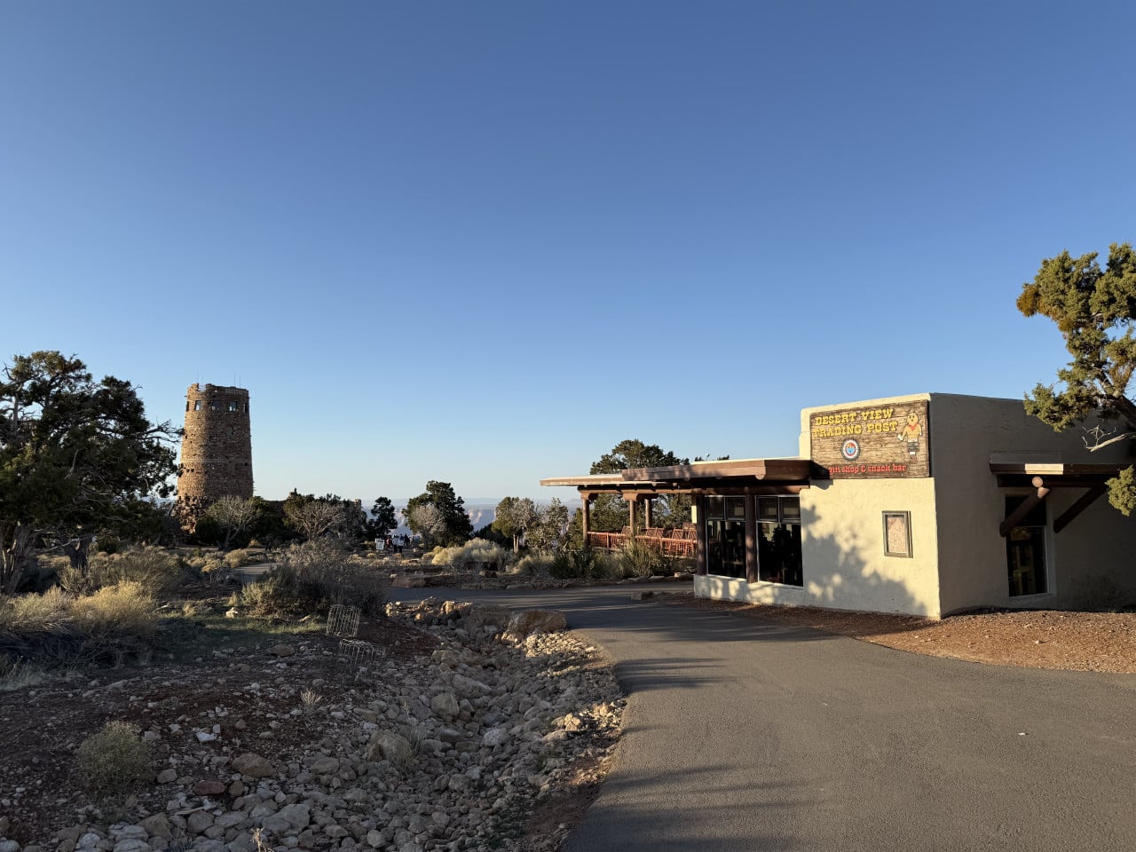 Pěšina k budově Desert View Trading Post, vlevo kamenná Watchtower, modrá obloha