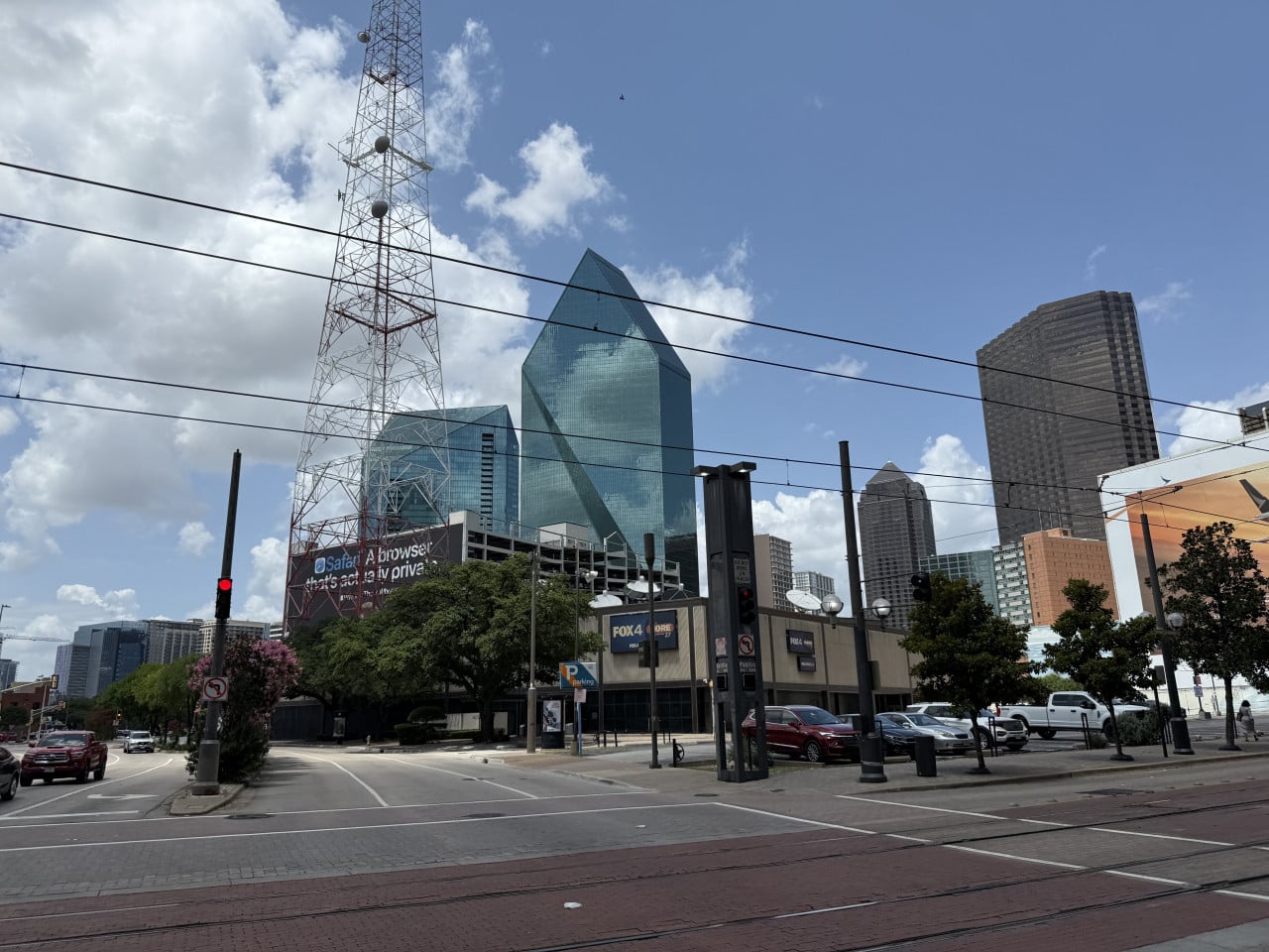 Křižovatka v downtown Dallasu, mrakodrapy, vysílací věž, auta, nápis FOX4.