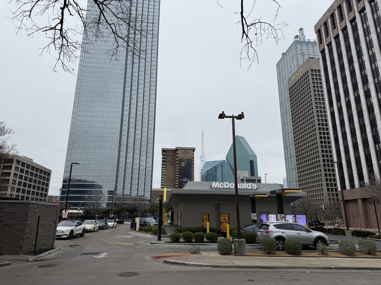 McDonald’s drive‑thru v downtown Dallas, v pozadí mrakodrapy a nápis WESTIN.
