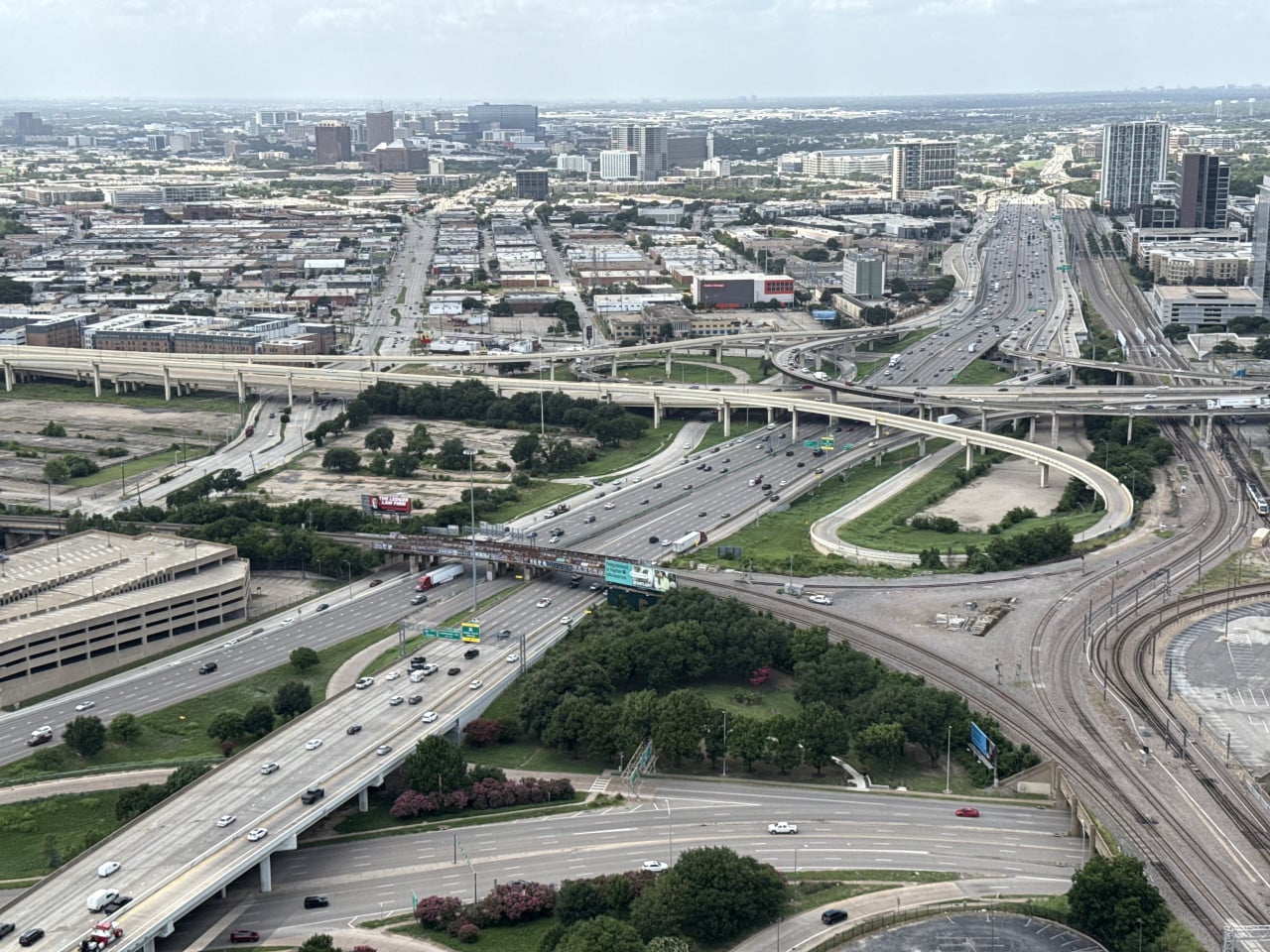 Letecký pohled na dálniční křižovatku v Dallasu, nadjezdy, auta a koleje.