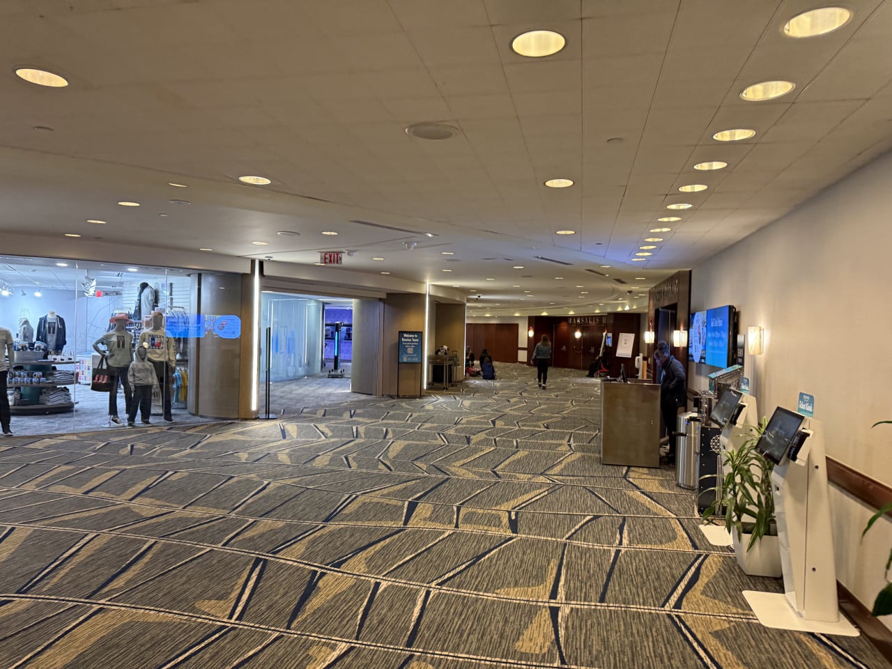 Chodba v kongresovém centru, obchod s figurínami, nápisy EXIT a MARSEILLES