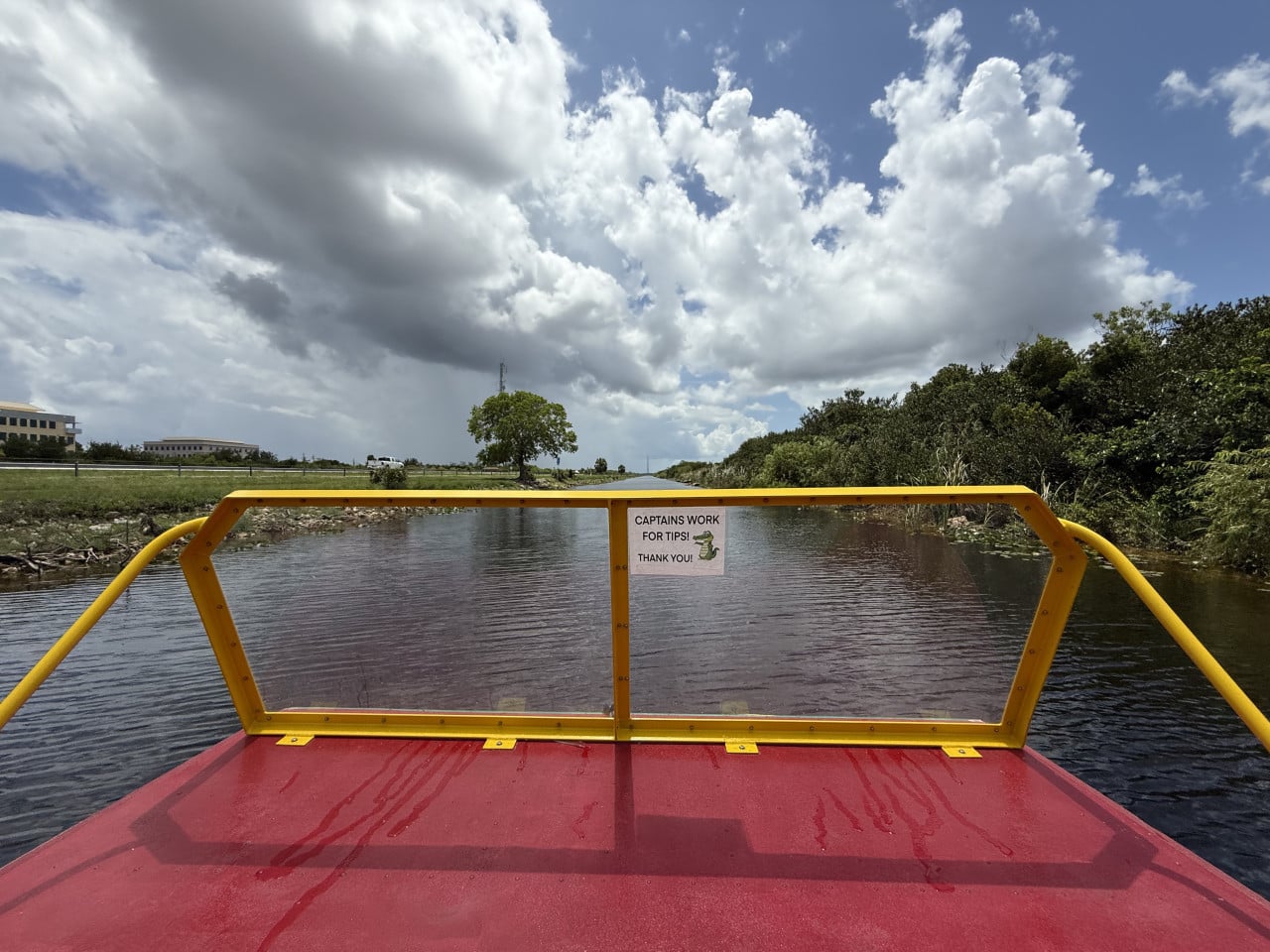 Pohled z airboatu na kanál v Everglades, s cedulí Captains work for tips.