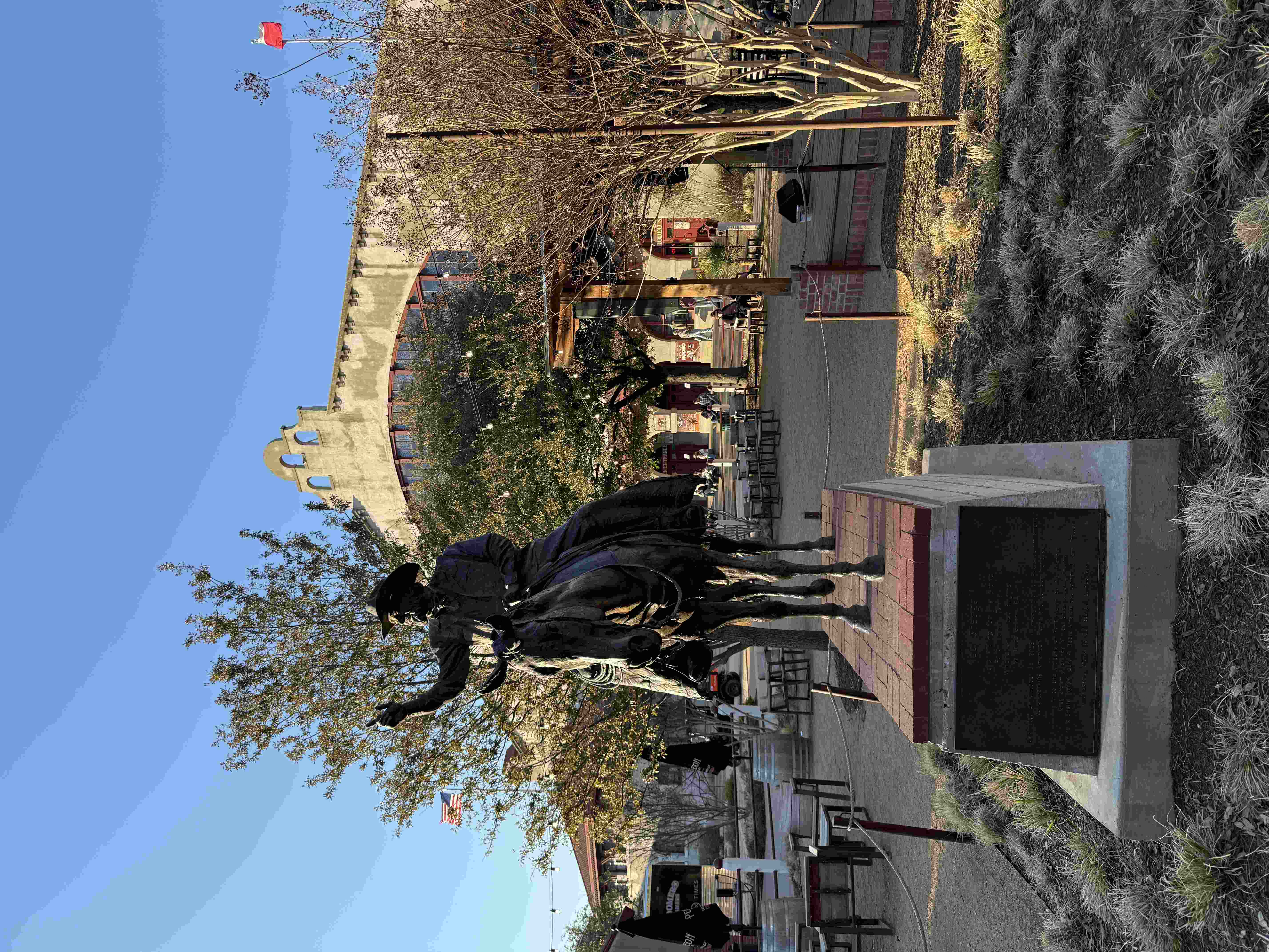 Socha kovboje na koni na podstavci před budovou Fort Worth Stockyards.