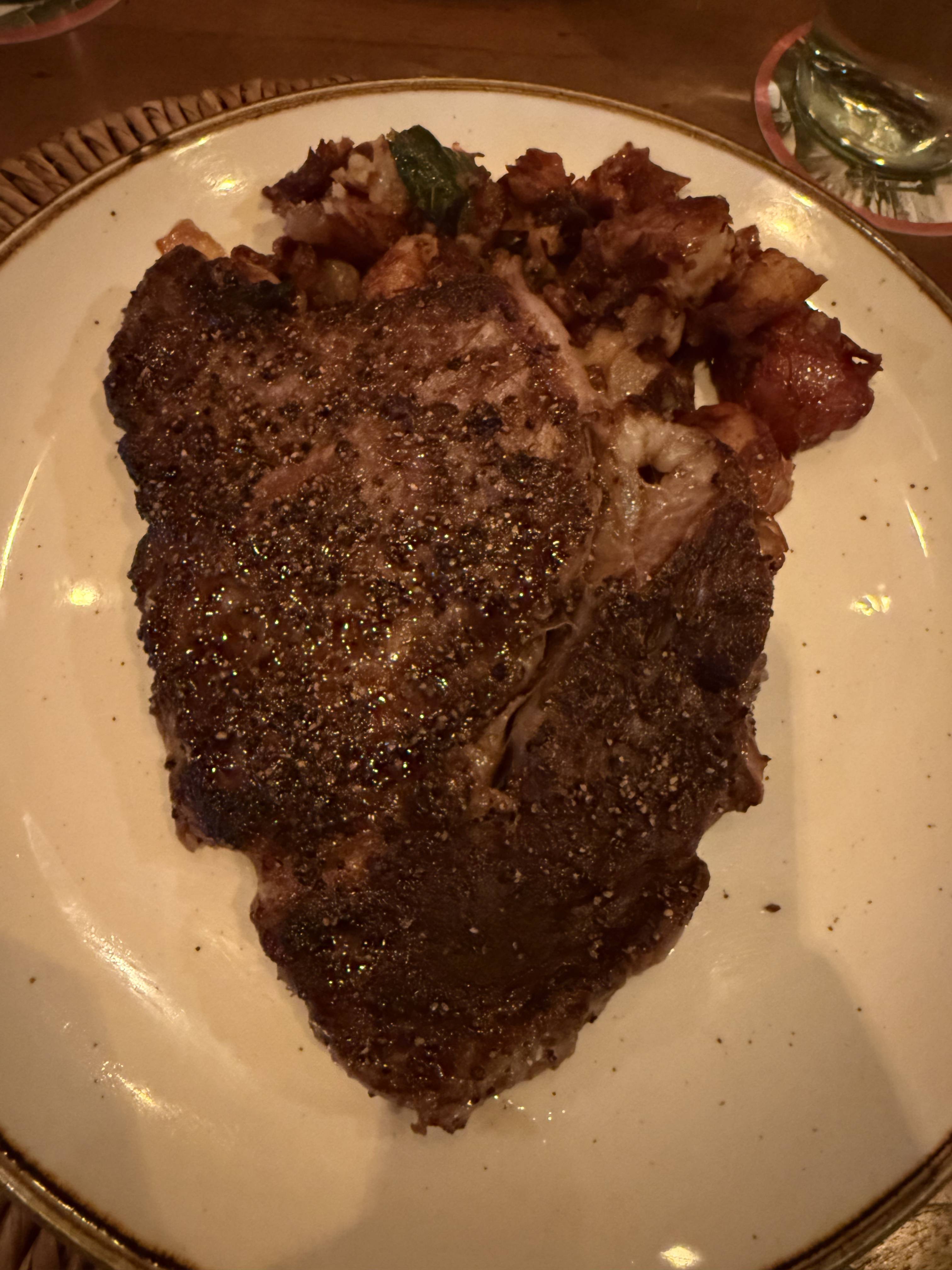 Grilovaný steak na talíři s opečenými bramborami a zelenou papričkou