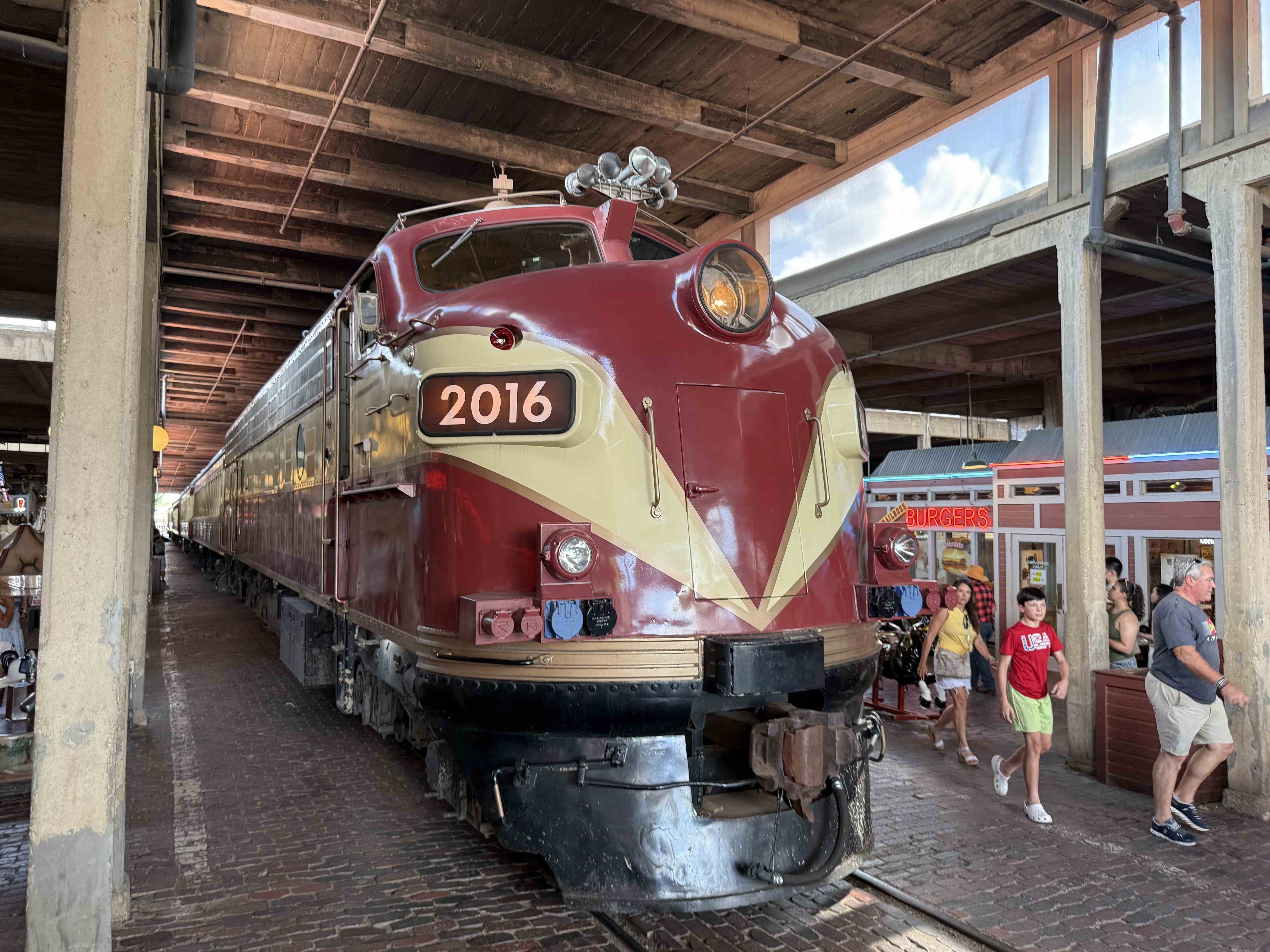 Historická lokomotiva s číslem 2016 ve Stockyards, v pozadí nápis BURGERS.