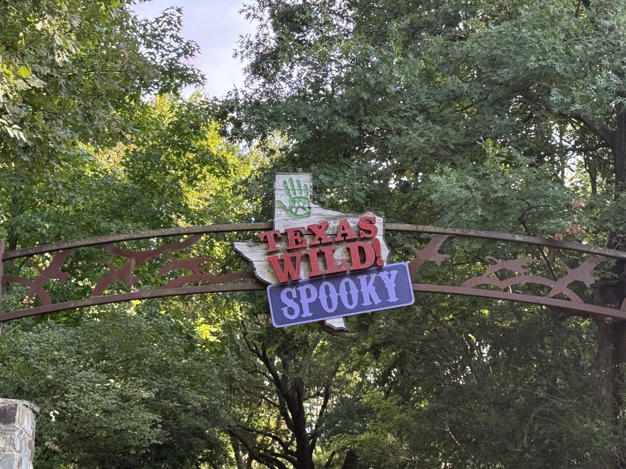 Vstupní brána s nápisem Texas Wild! Spooky mezi stromy v zoo