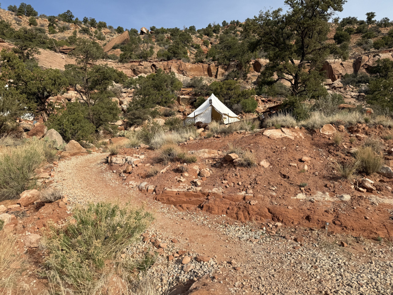 Pěšina v červeném kaňonu vede k bílému glampingovému stanu s číslem 5.