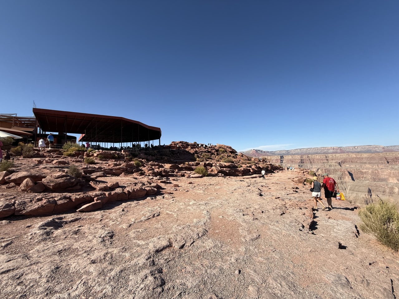 Vyhlídková terasa na okraji Grand Canyonu s turisty a skalnatou krajinou