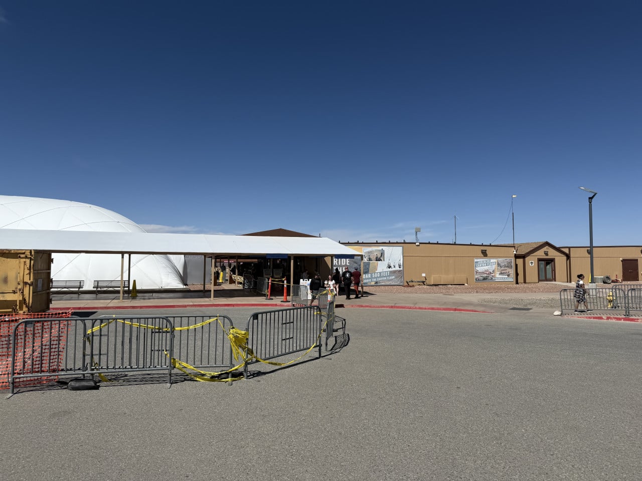 Vstupní areál Skywalku s bílou kupolí, zábranami a návštěvníky u budovy