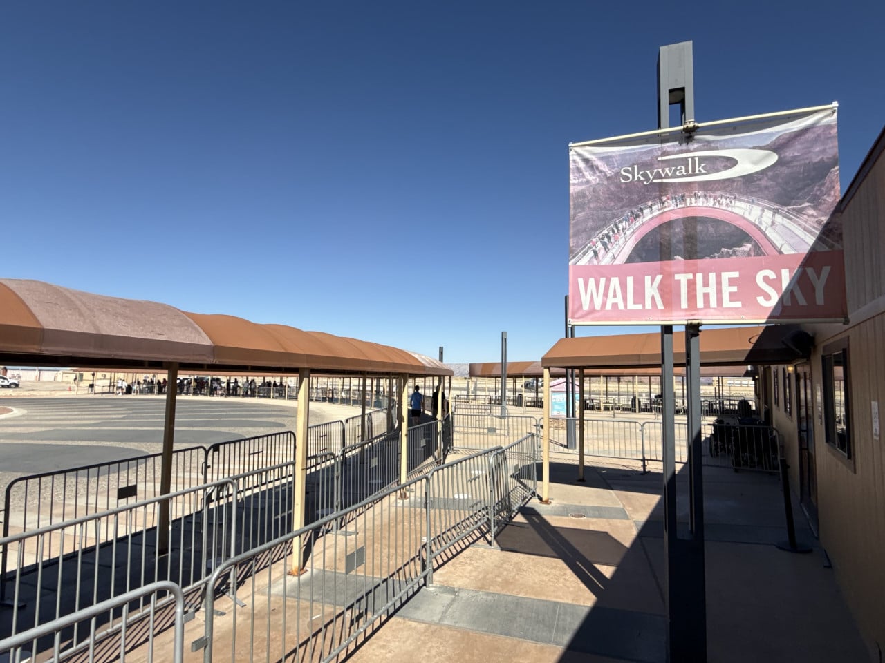 Vstupní areál Skywalku s nápisem WALK THE SKY a kovovými zábranami.