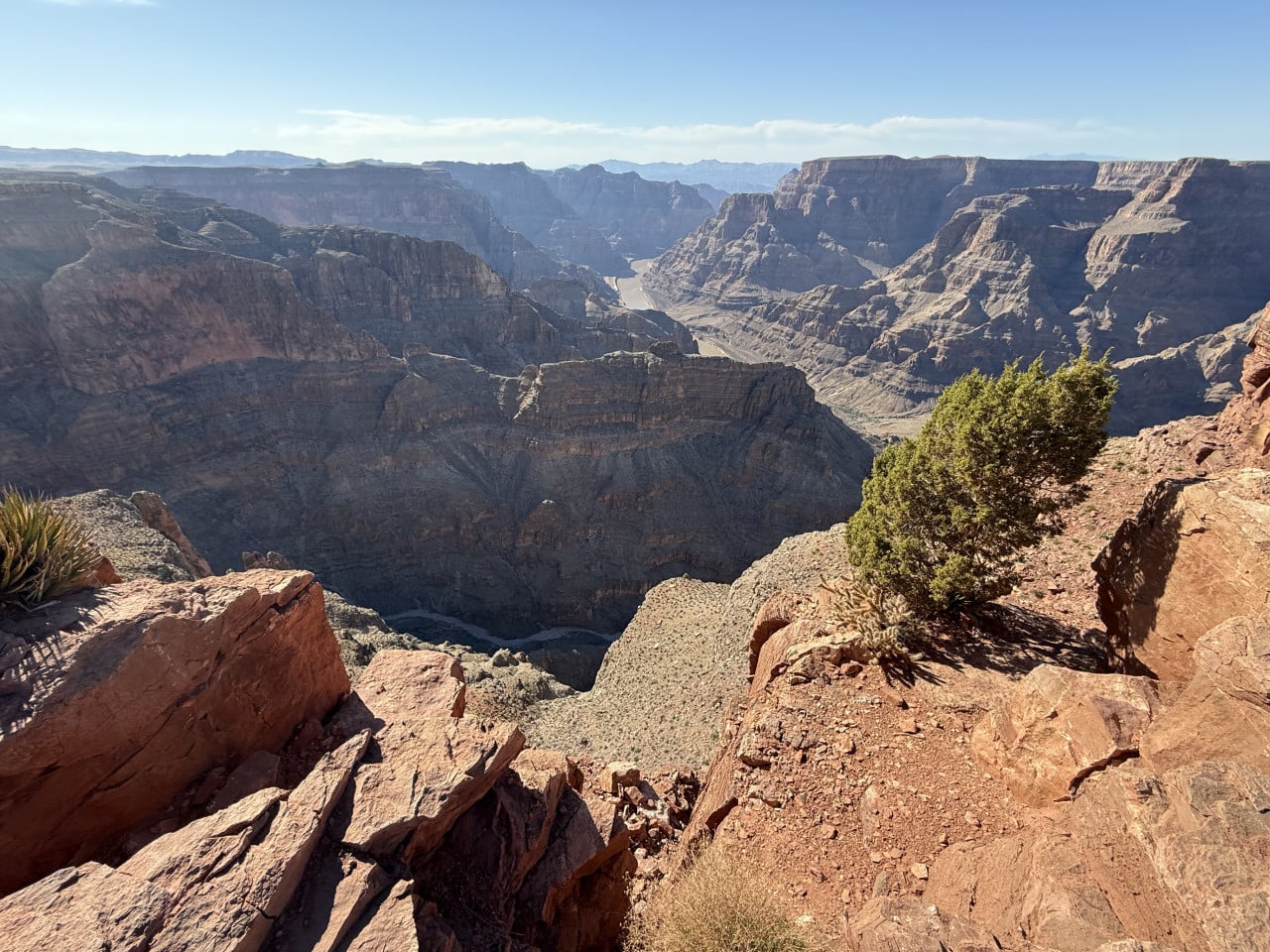 Pohled na rozlehlý Grand Canyon s kamennými útesy a říčním údolím.