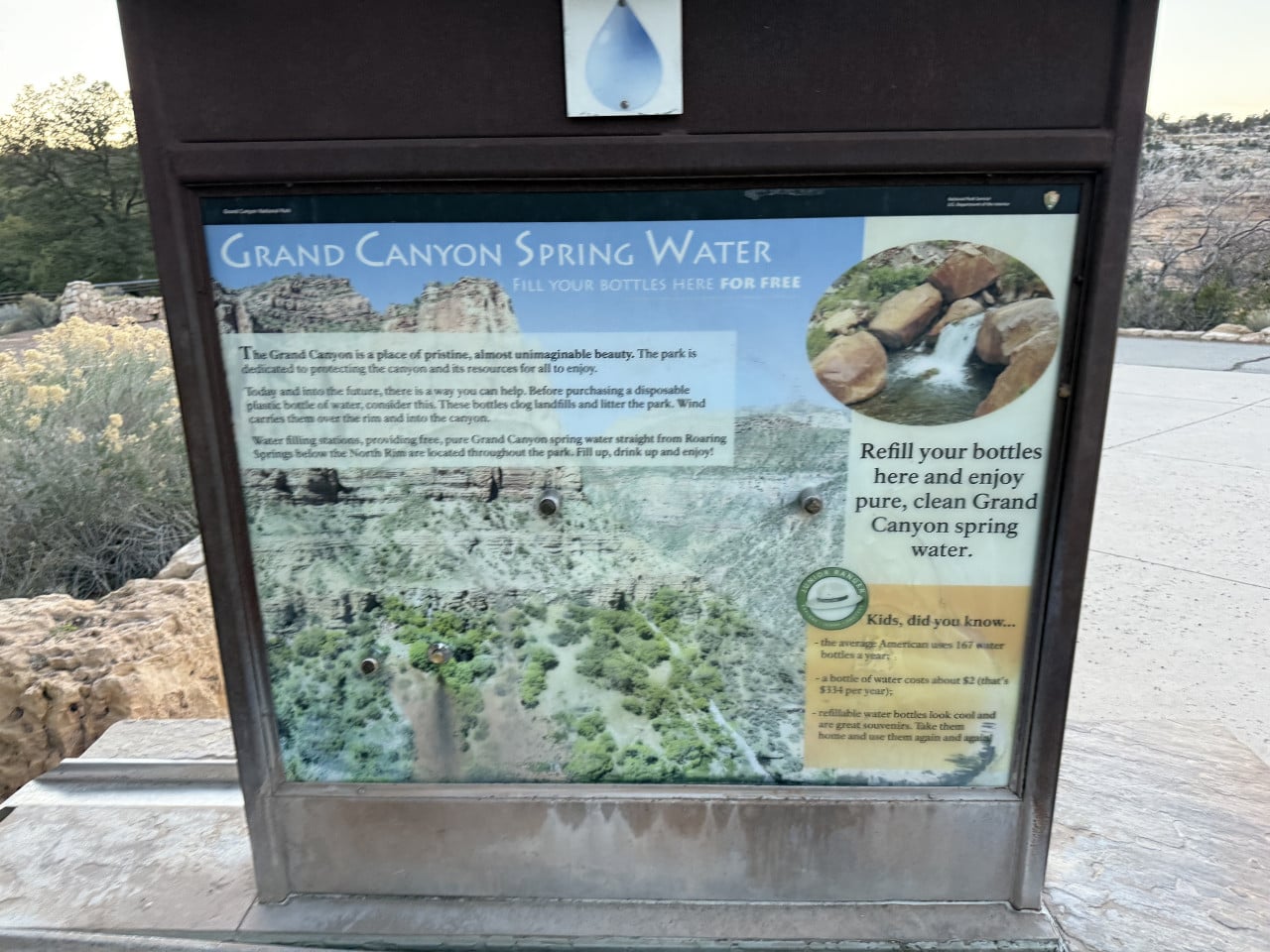 Informační tabule Grand Canyon Spring Water s textem o doplňování lahví zdarma.