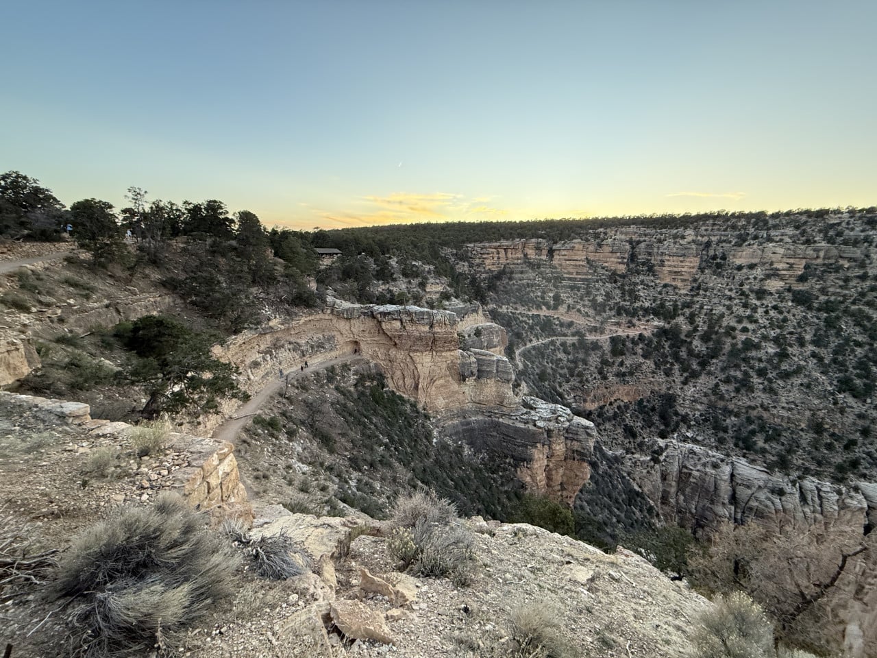 Stezka po okraji Grand Canyonu za úsvitu s útesy a skalními věžemi