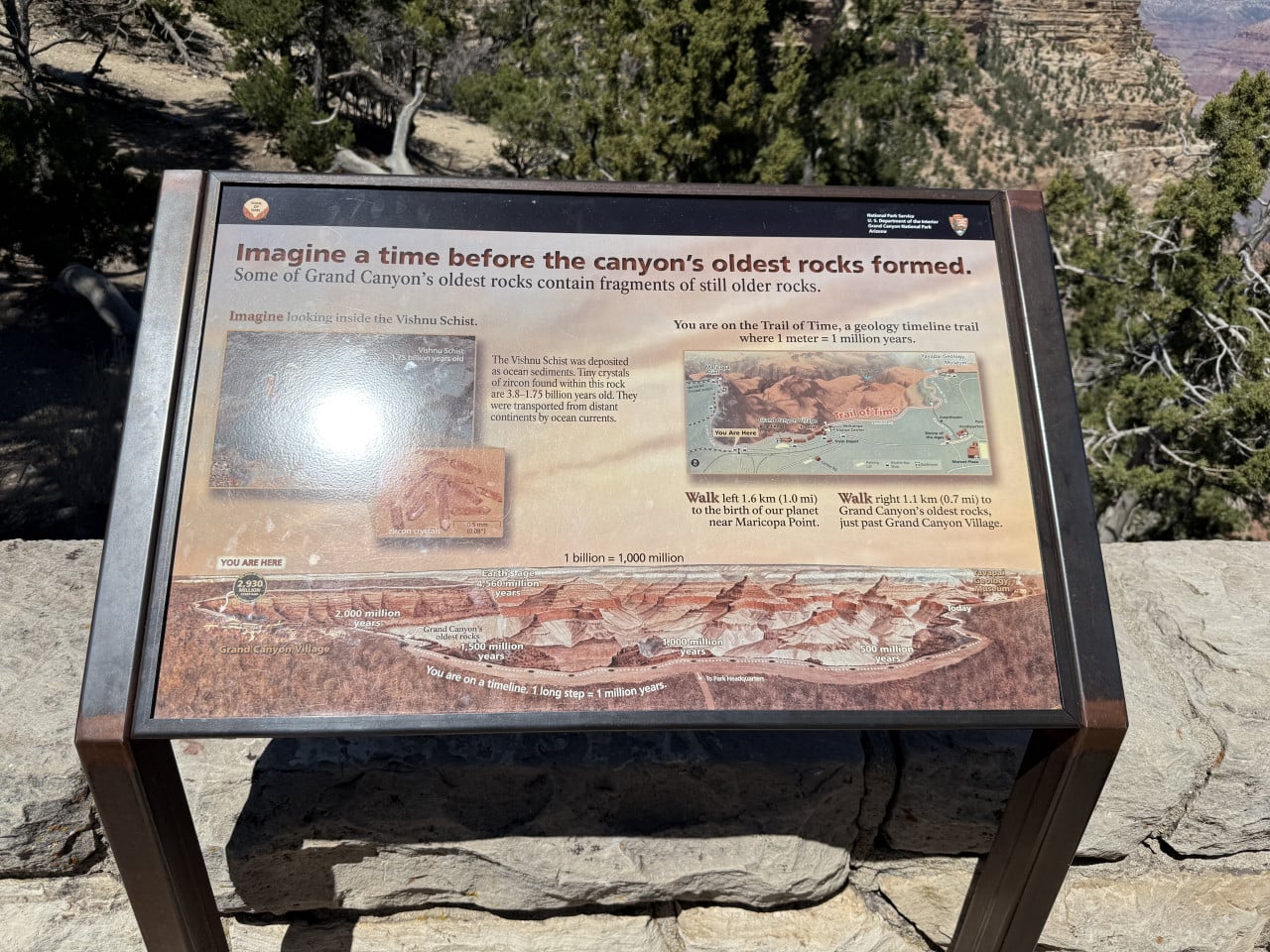 Informační cedule Trail of Time s mapou Grand Canyonu a skalnatým pozadím