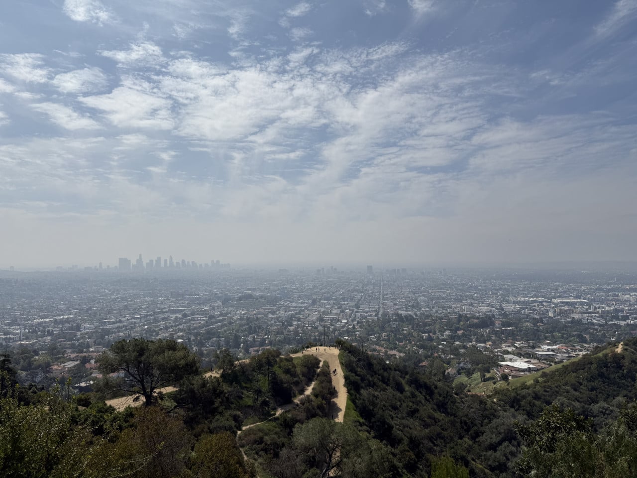 Pohled z Griffith Observatory na Los Angeles, skyline a stezku v Griffith Parku.