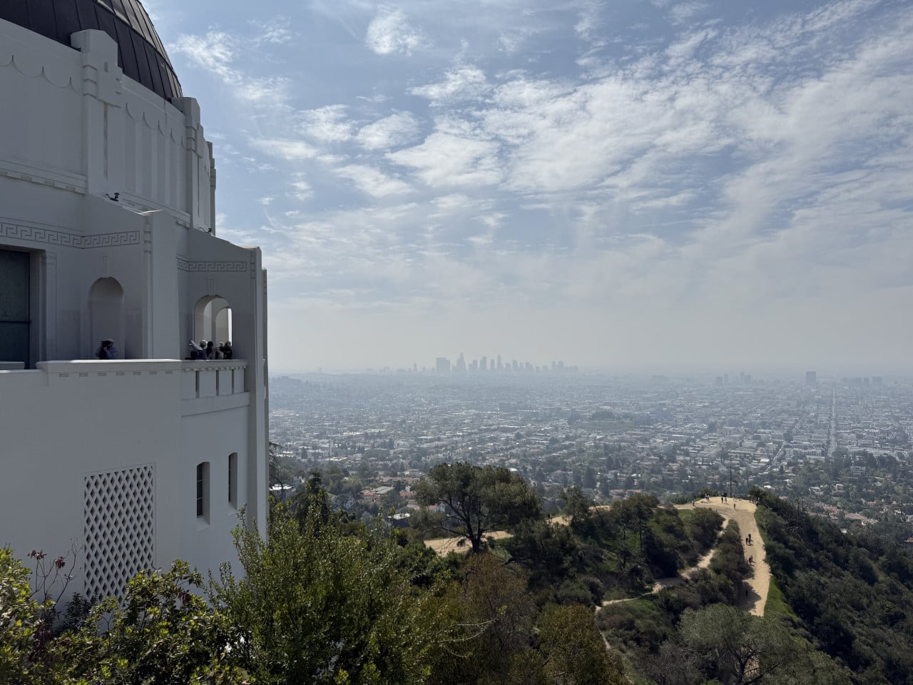 Griffith Observatory s výhledem na panorama Los Angeles a kopcovitou stezku pod ním