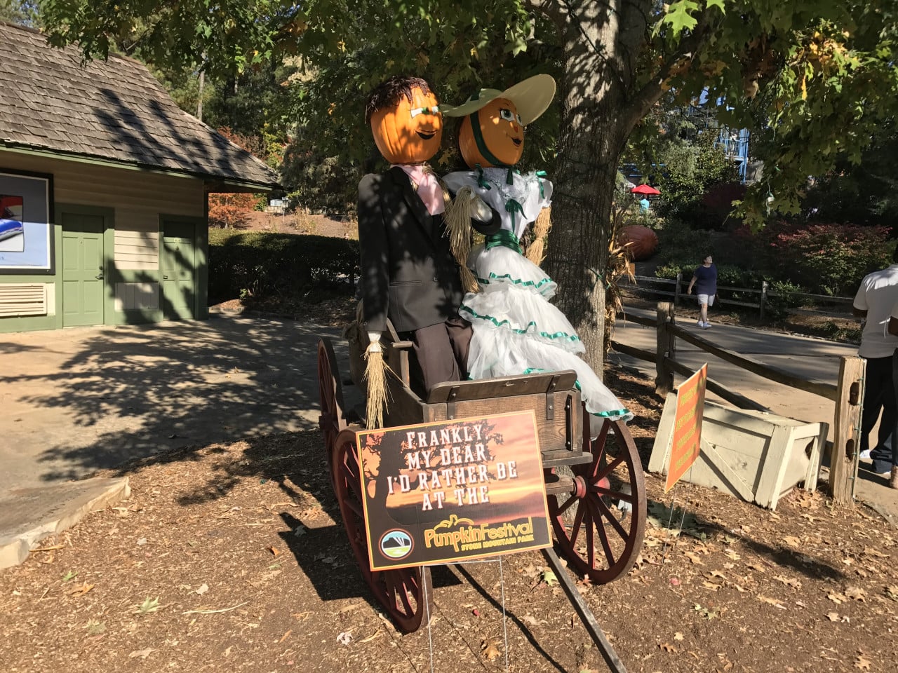 Strašákový pár s dýňovými hlavami na vozíku u podzimní dekorace, Pumpkin Festival.