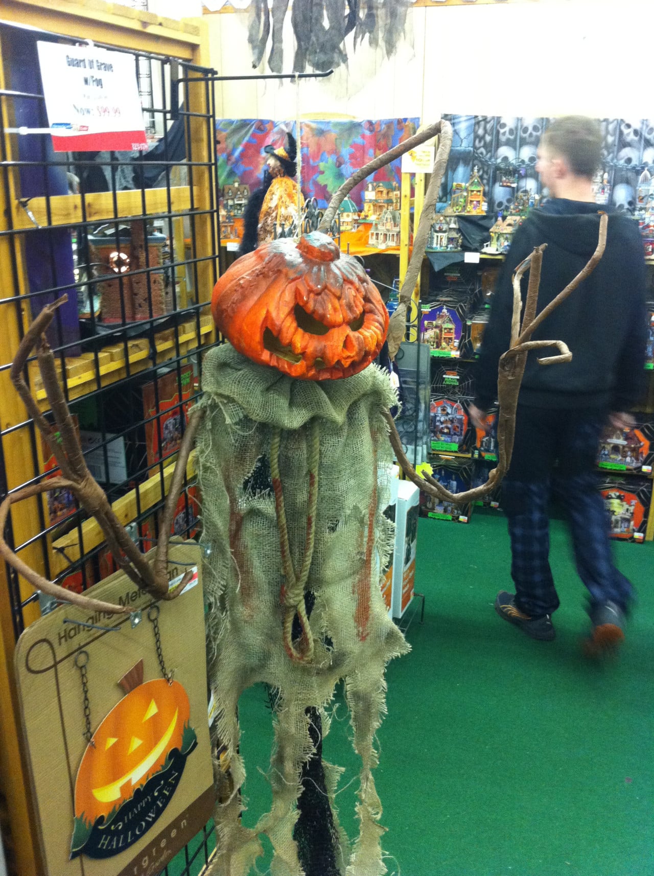 Strašidelná halloweenská dekorace s dýní a kostýmovaným interiérem obchodu