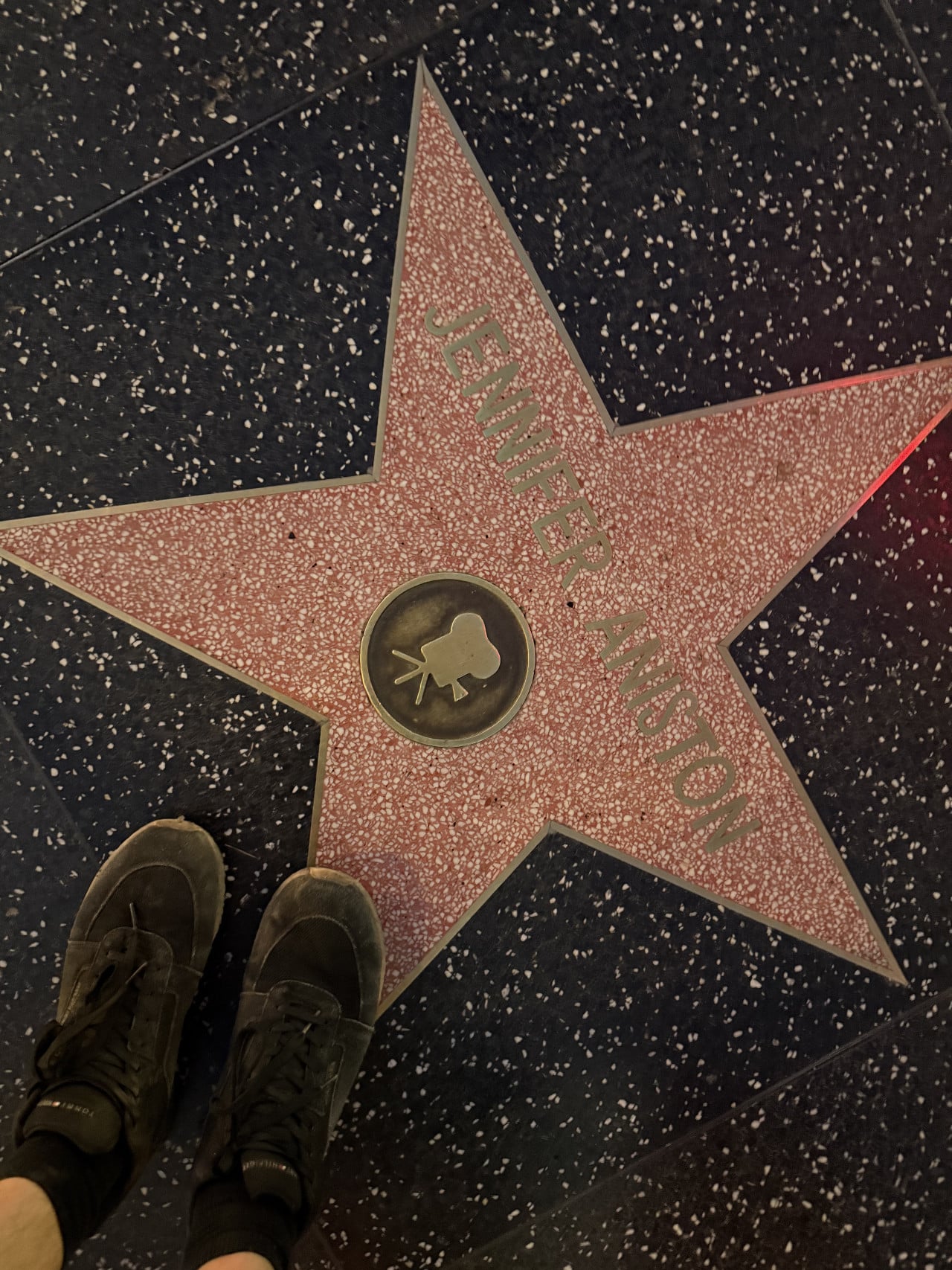 Hvězda Jennifer Aniston na Hollywoodském chodníku slávy s botami v dolním rohu.