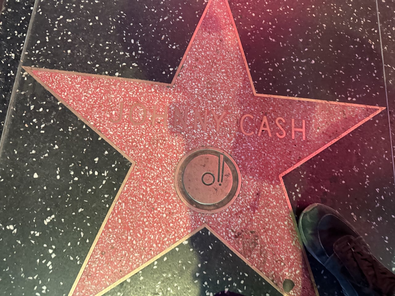 Hvězda Johnyho Cashe na Hollywoodském chodníku slávy, část boty v rohu.