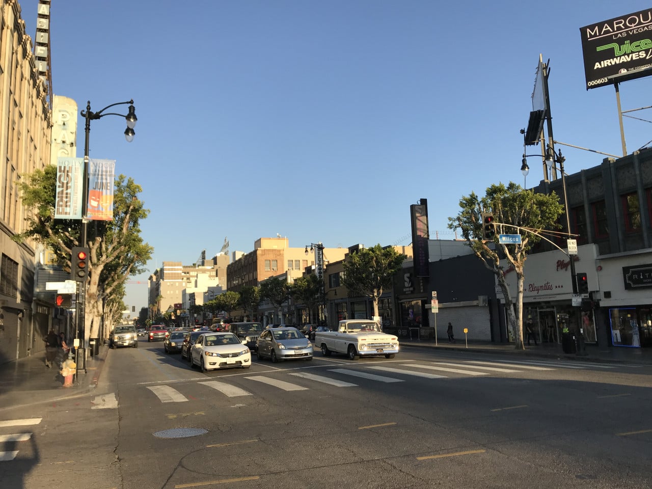 Rušná hollywoodská ulice s auty, semafory, obchody a billboardem Marquee Las Vegas.