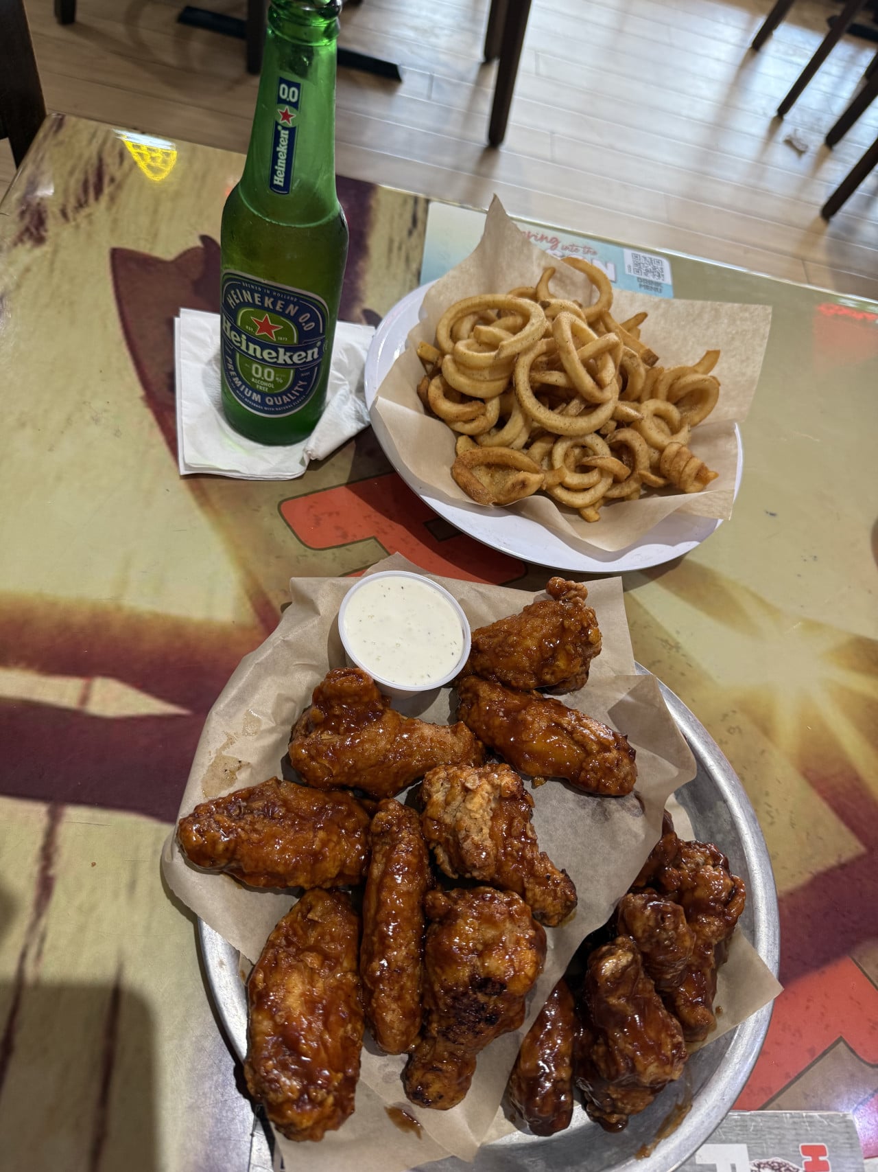 Láhev Heineken 0.0, kuřecí křidélka s dipem a curly hranolky.