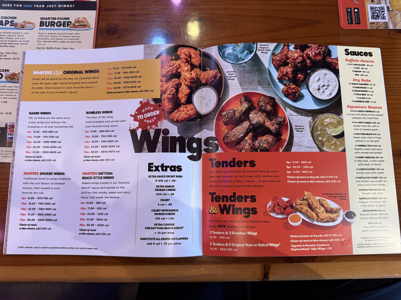 Otevřené menu Hooters na stole, stránky Wings, Tenders a Sauces