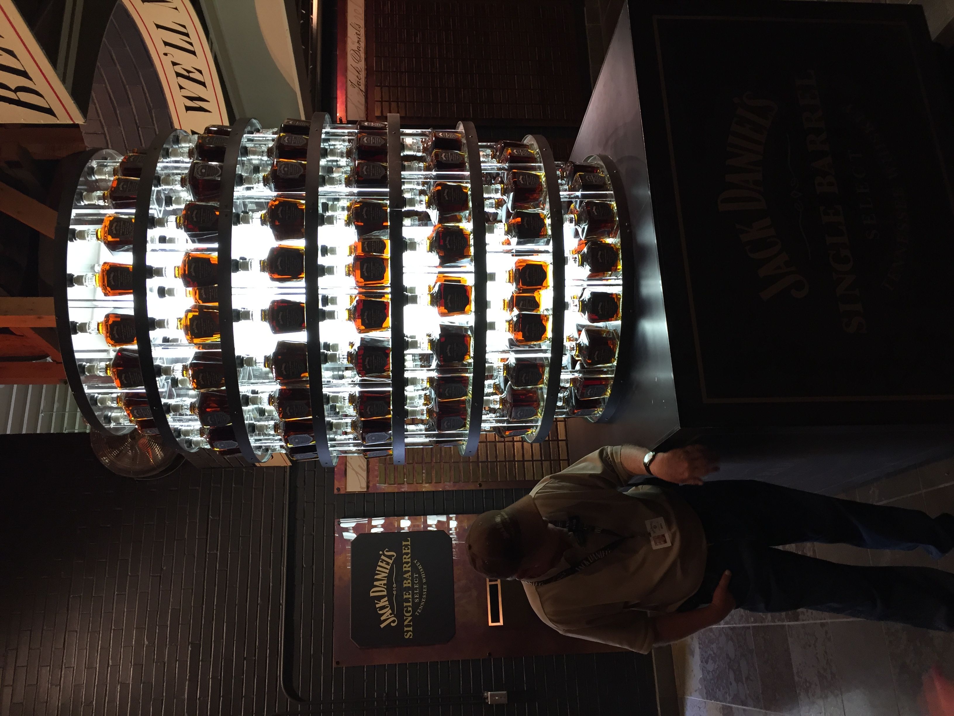 Osvětlený stojan s lahvemi Jack Daniel’s Single Barrel Select, průvodce vedle