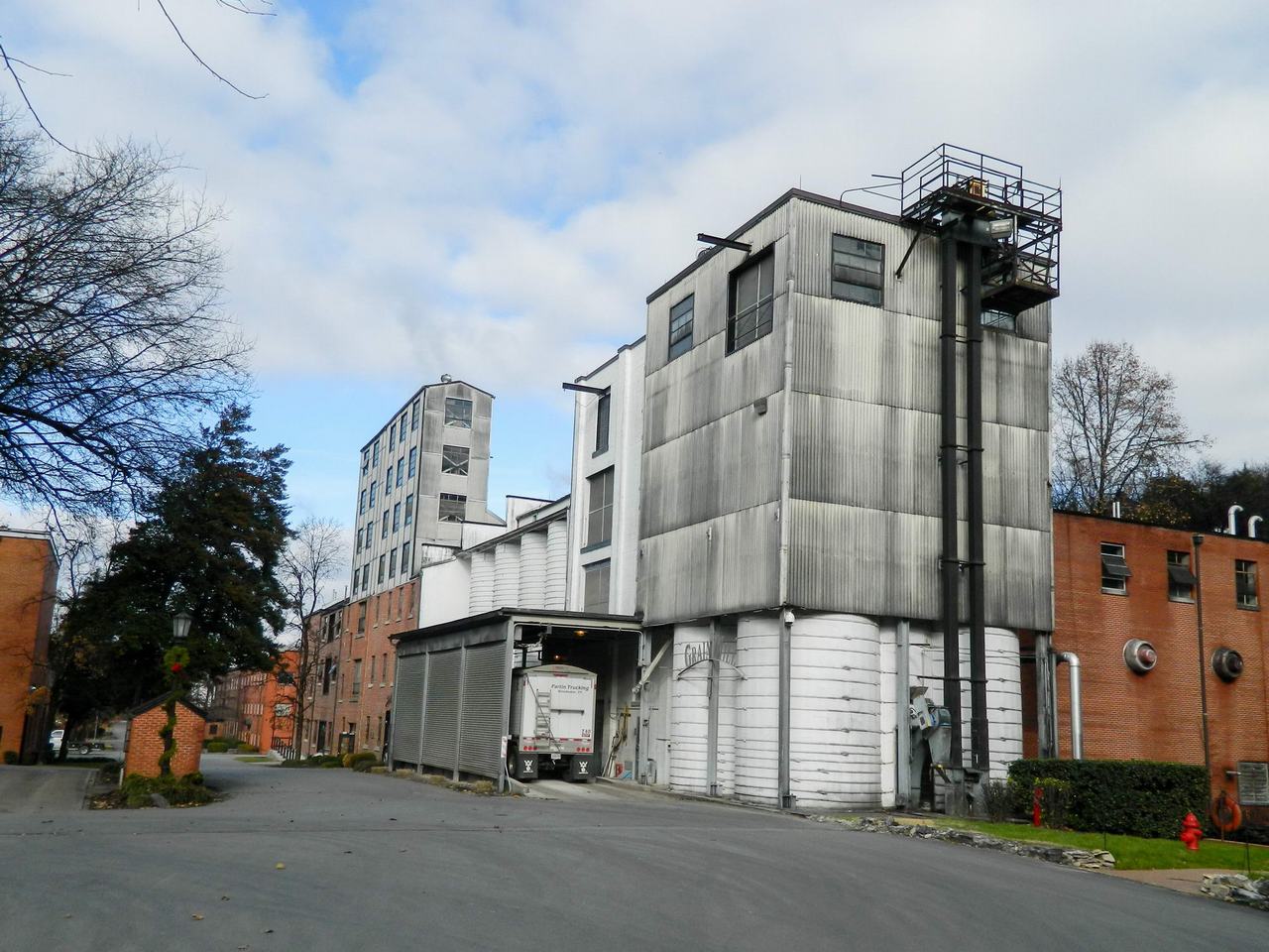 Průmyslové budovy destilerie s nakládací rampou a kamionem Pacific Trucking.