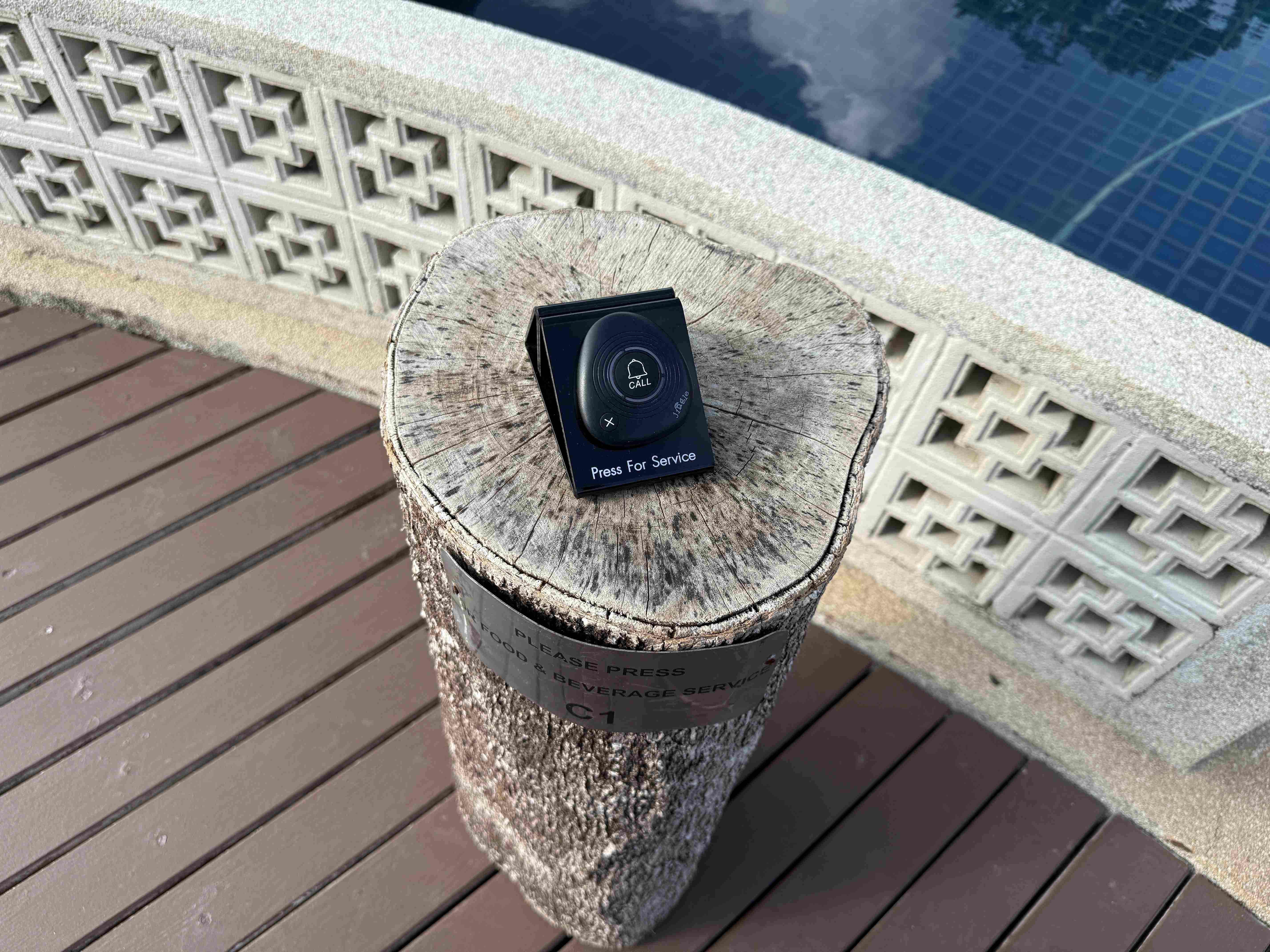 Servisní tlačítko u bazénu na pařezu, nápis Press For Service.