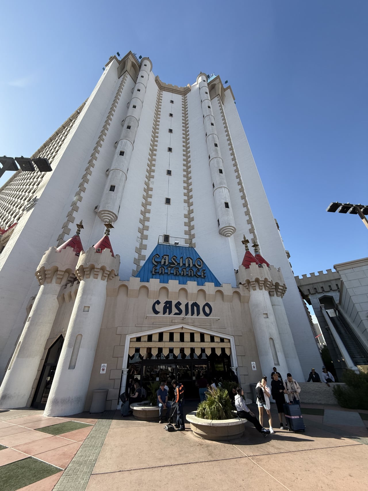 Vstup do kasina s nápisy CASINO ENTRANCE a CASINO, lidé před vchodem