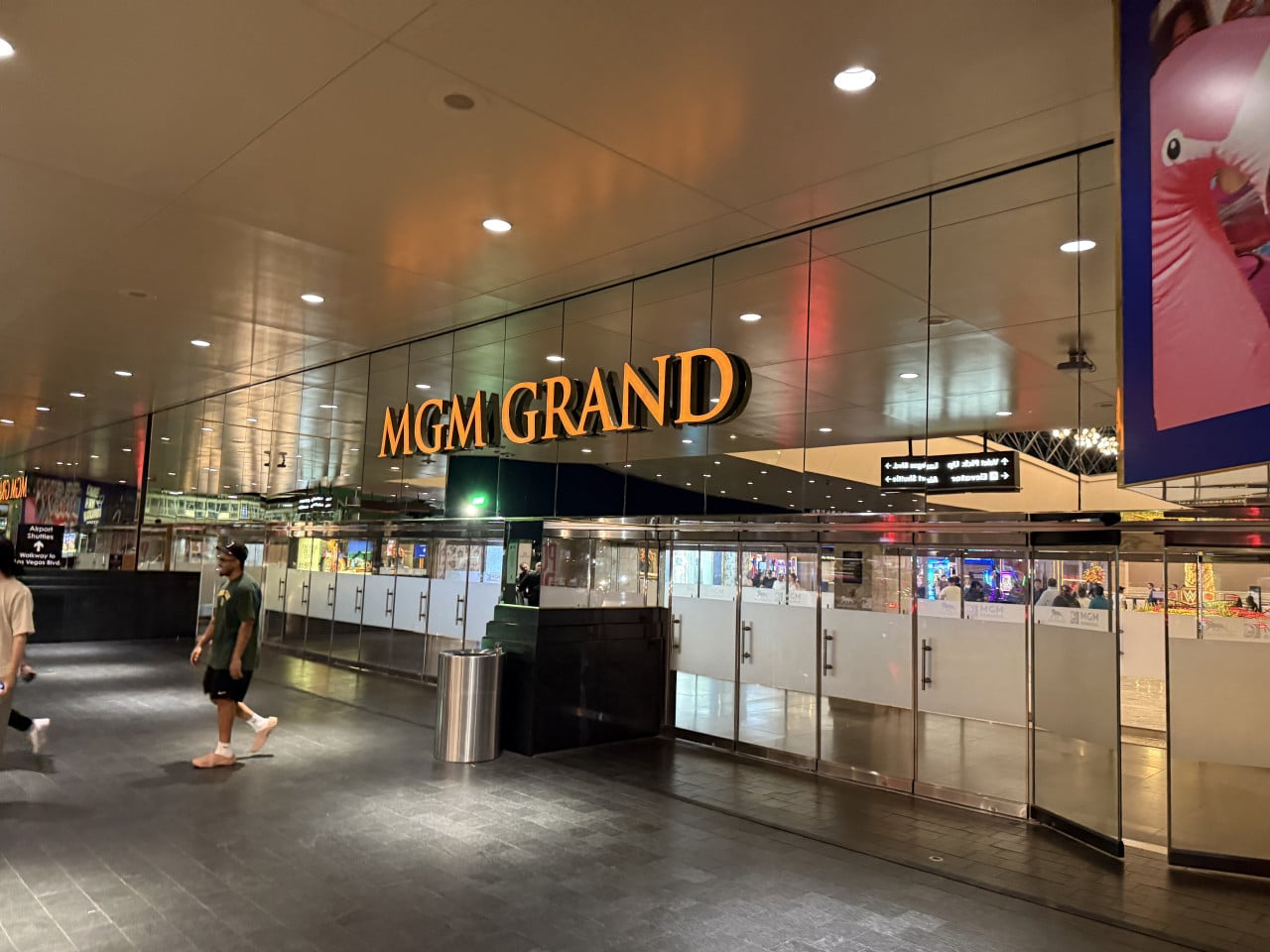Vstup do hotelu MGM GRAND s prosklenou stěnou, lidé procházejí