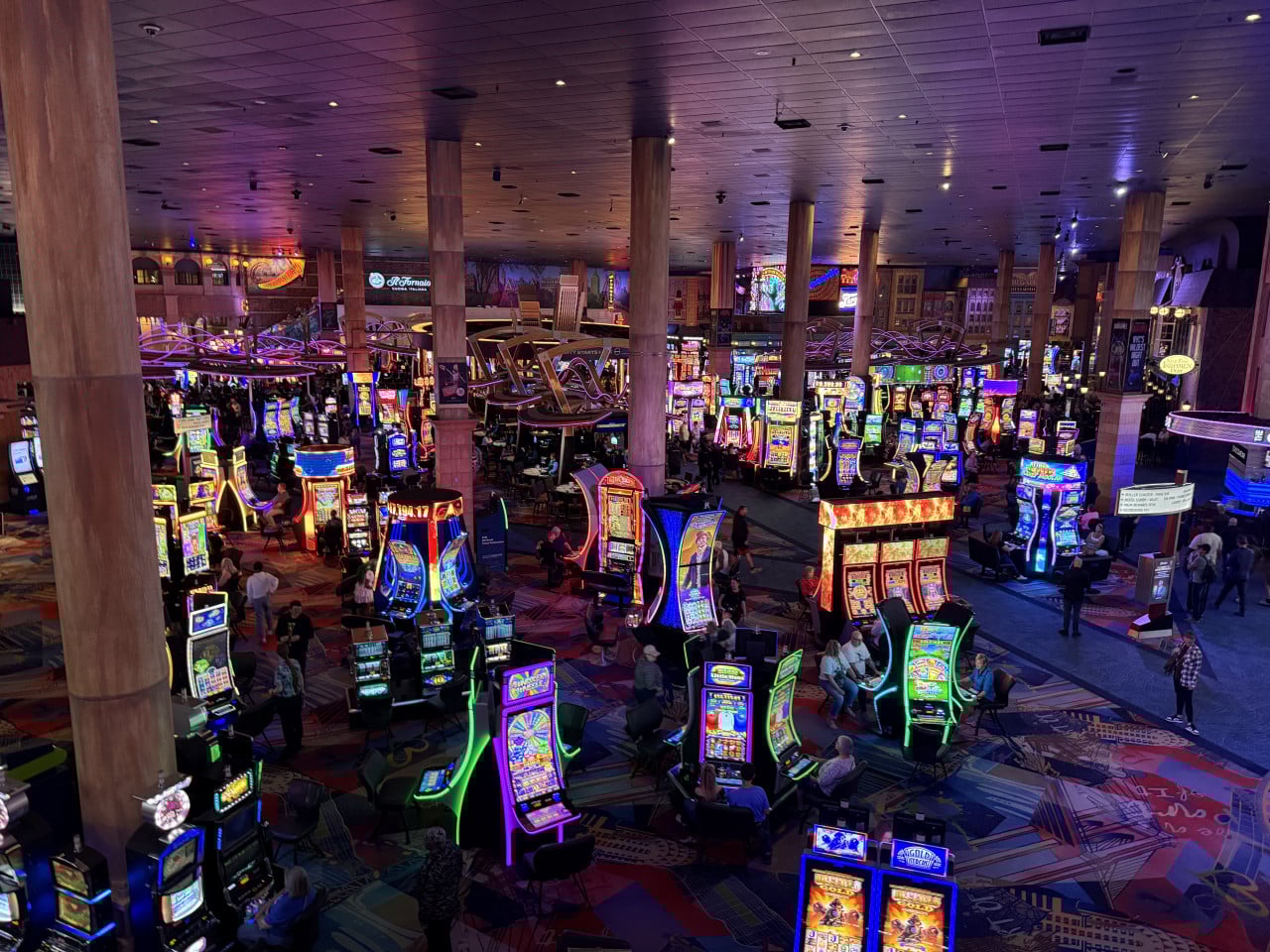 Interiér kasina v Las Vegas, barevné automaty, lidé, nápis Il Fornaio.