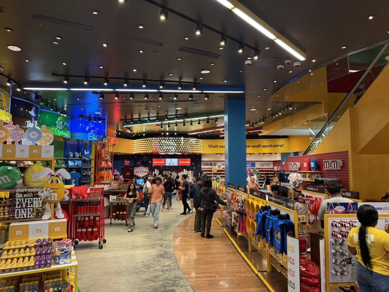 Interiér obchodu M&M’s World, dav lidí, nápis LAS VEGAS v pozadí.