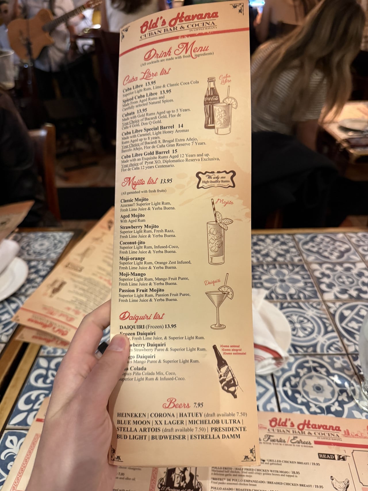 Ruka drží Drink Menu Old’s Havana Cuban Bar & Cocina v restauraci.