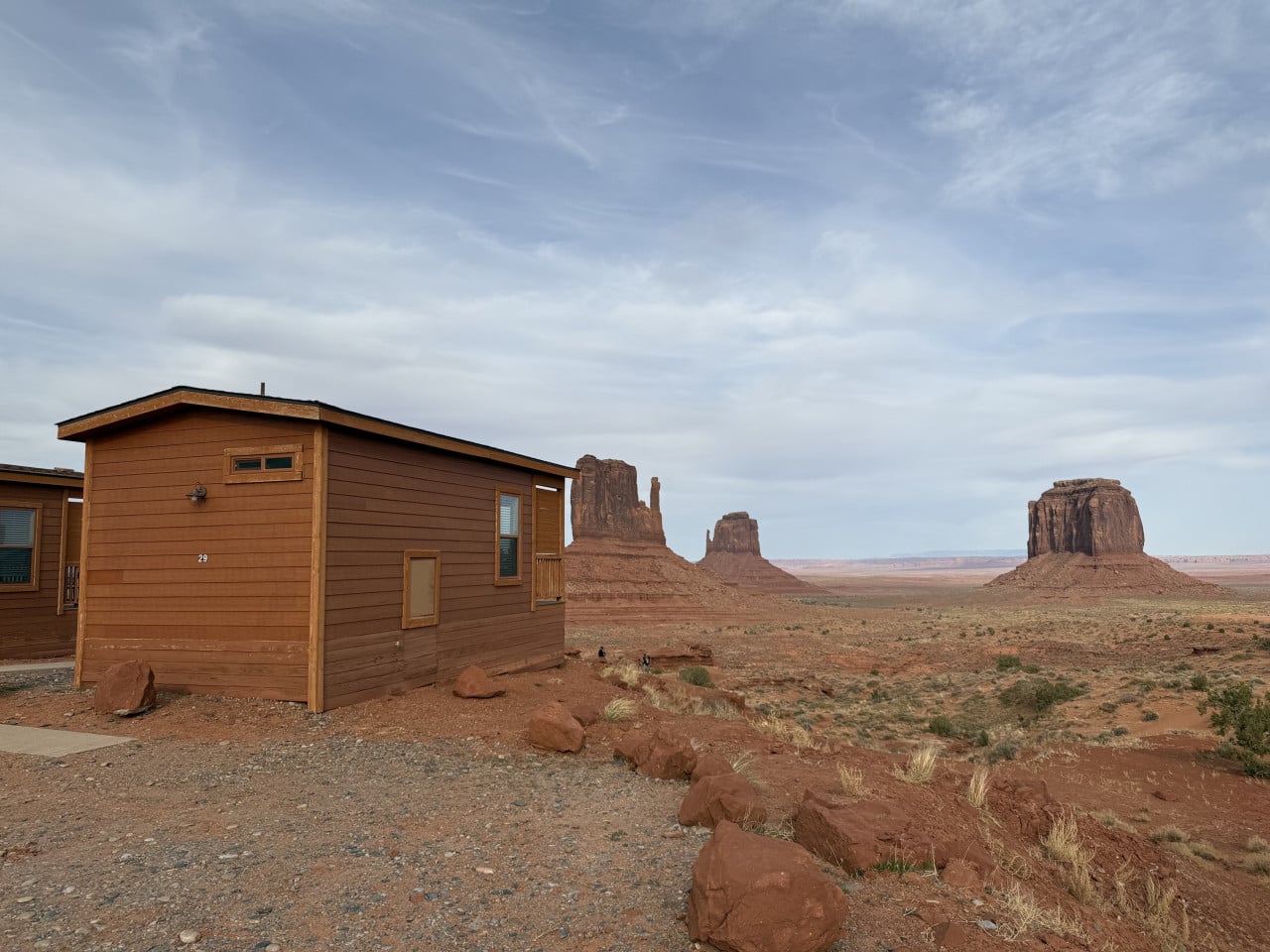 Dřevěná chatka s číslem 29, v pozadí skalní monumenty Monument Valley.