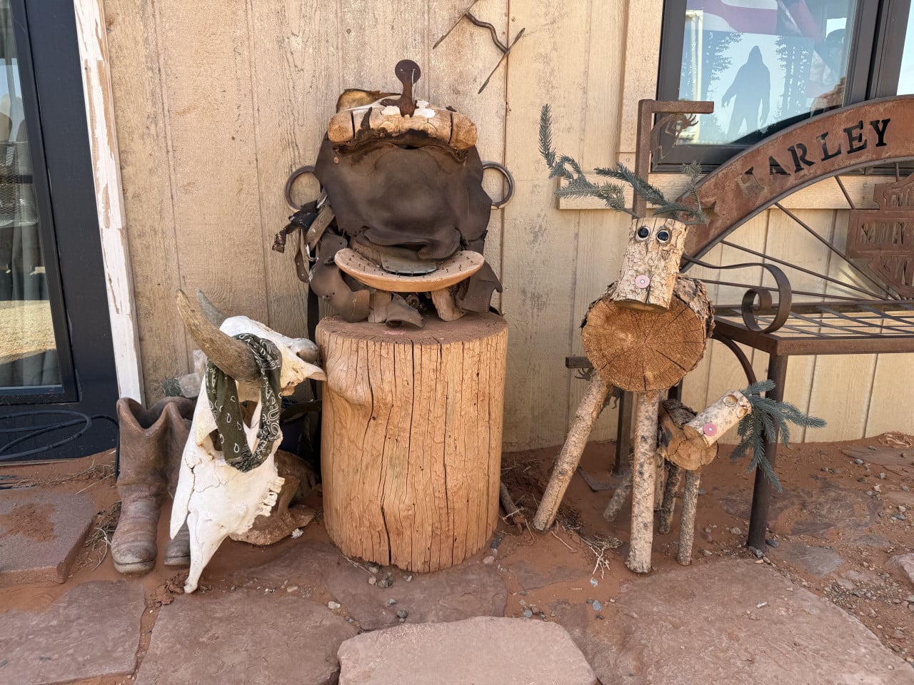 Kovová lavička s nápisem VALLEY, dřevěná zvířata, kovbojské boty a lebka