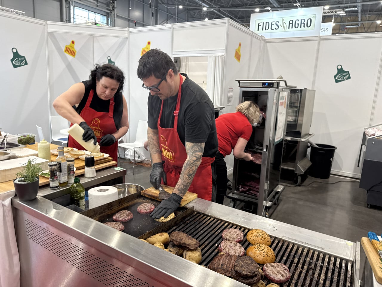 Stánek Fides Agro, kuchaři připravují burgery a grilované maso na veletrhu.