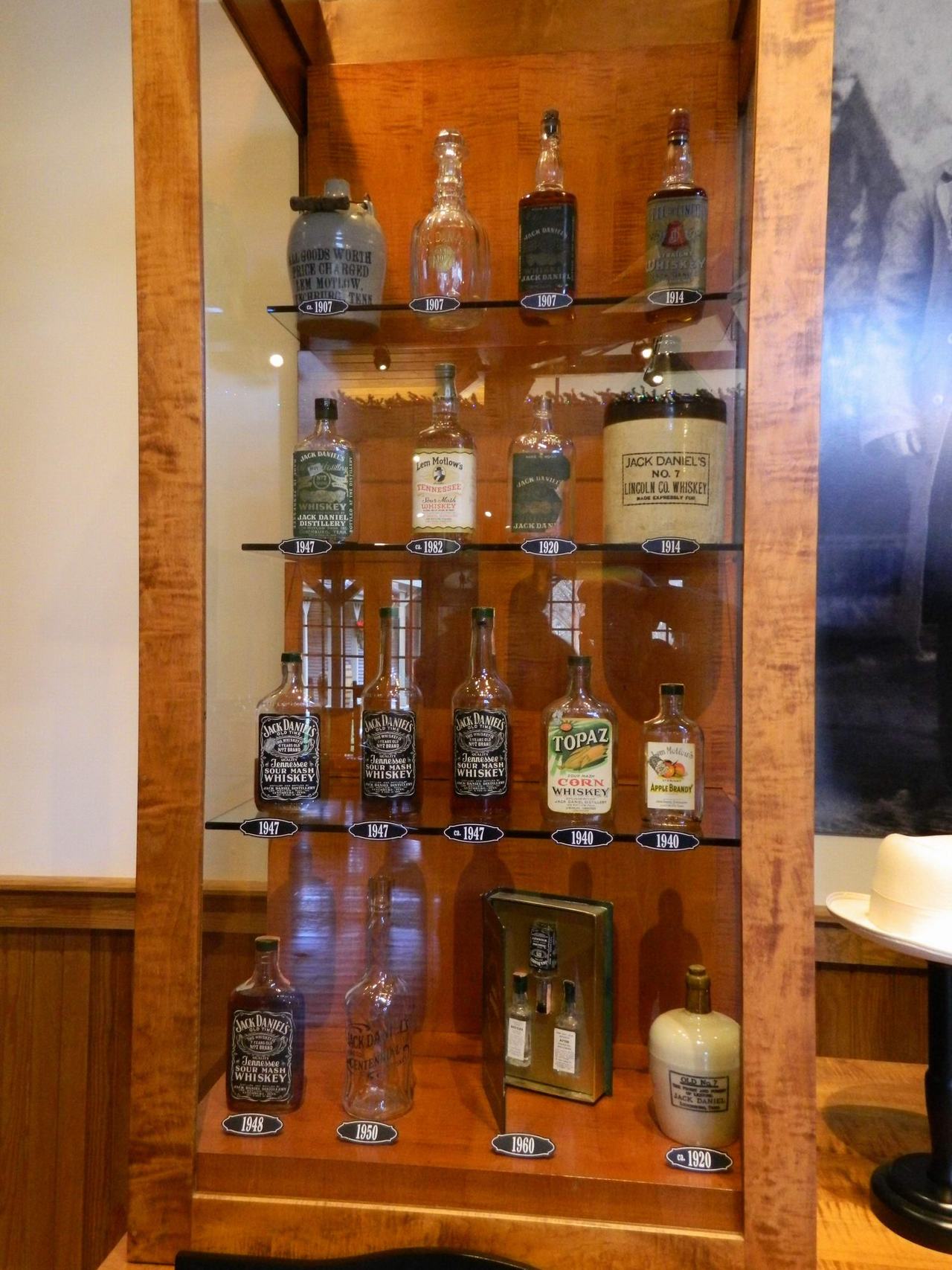 Vitrína s historickými lahvemi Jack Daniel’s Old No. 7, TOPAZ, roky 1907–1960.
