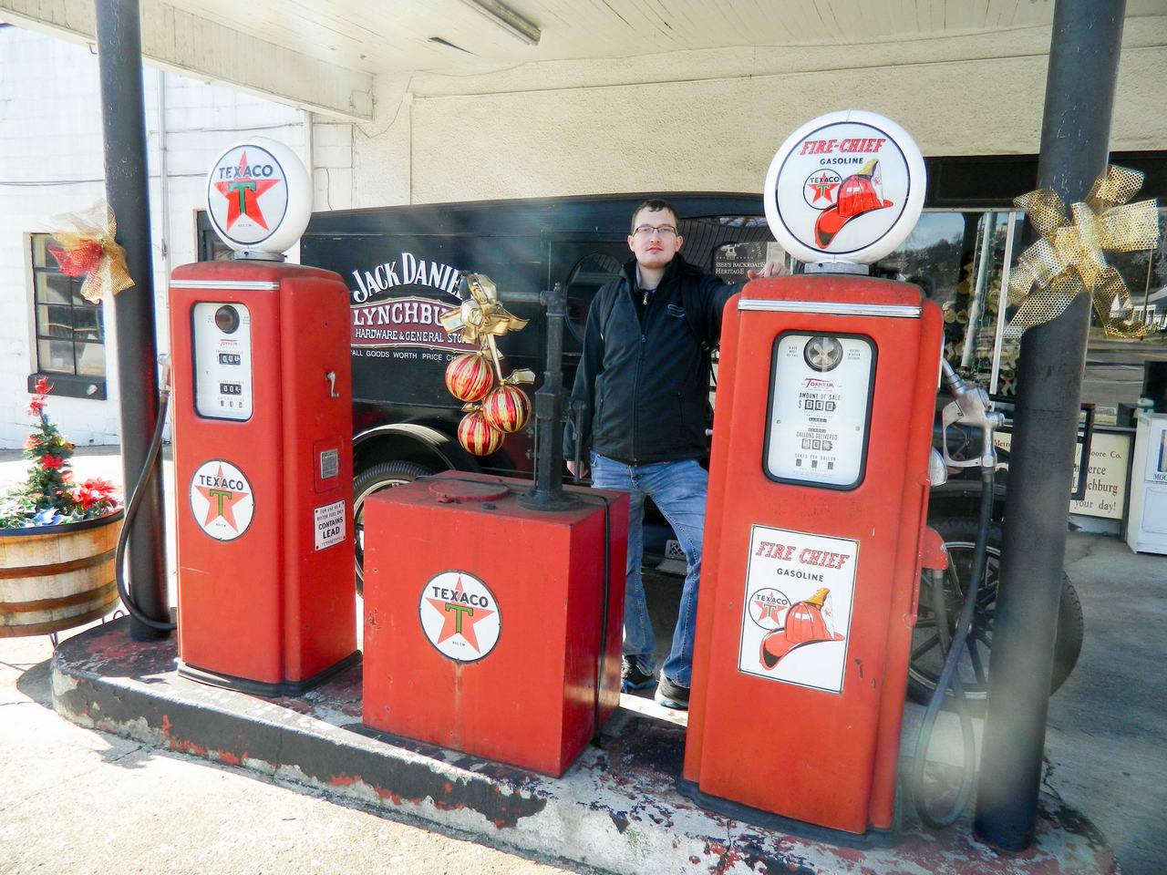 Muž mezi retro stojany TEXACO a FIRE CHIEF GASOLINE, v pozadí Jack Daniel’s Lynchburg.