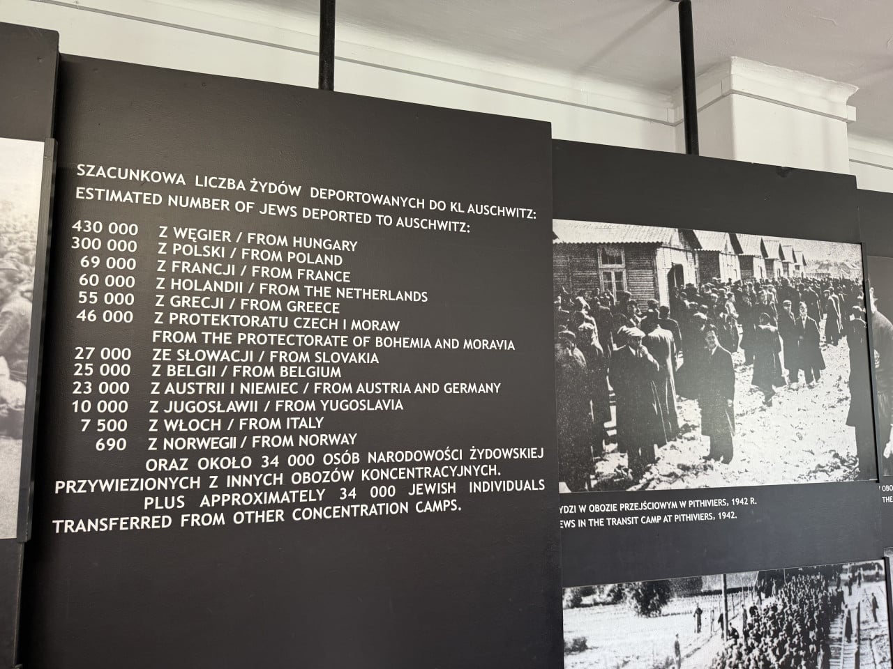 Informační panel s počty deportovaných Židů do Auschwitz a historickou fotografií vězňů v táboře.