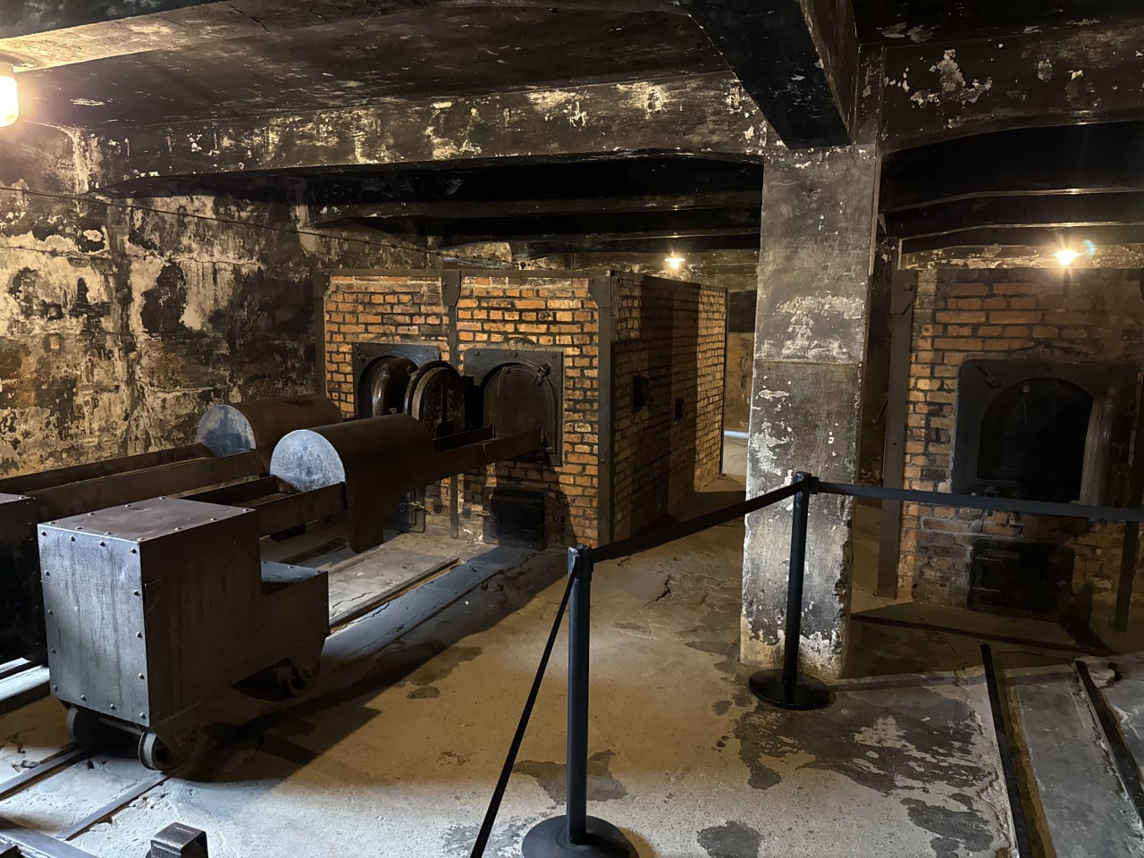 Plynové komory s mřížemi a pecemi v temném podzemí Auschwitz-Birkenau